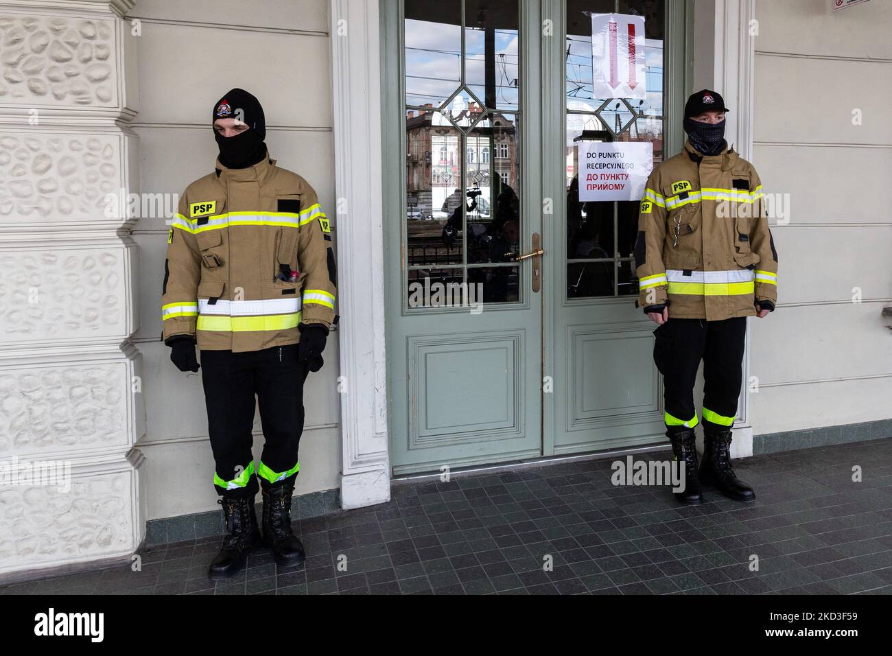 Feuerwehrleute bewachen den Eingang zum Bahnhof in Przemysl, als erste Migranten aus der Ukraine nach Polen eintreffen, nachdem Russland am 25. Februar 2022 ukrainisches Territorium bombardiert hatte. Alle öffentlichen Dienste wurden engagiert, um die Krise zu bewältigen. Da die Armee der Russischen Föderation die ukrainischen Grenzen überschritten hat, wird der Konflikt zwischen der Ukraine und Russland voraussichtlich 5 Millionen Ukrainer zur Flucht zwingen. Die meisten Flüchtlinge werden in Polen Asyl beantragen. Die meisten Flüchtlinge kamen in Grenzstädte wie Przemysl und siedeln in Innenstädte um. (Foto von Dominika Zarzycka/NurPhoto) Stockfoto