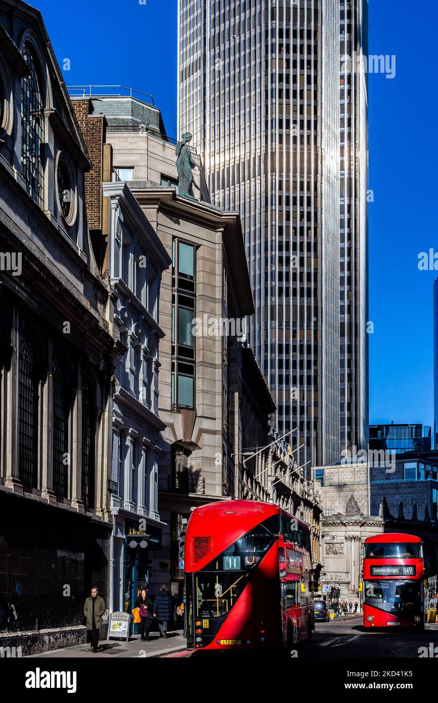 Zwei rote Londoner Routmaster-Busse fahren aneinander vorbei und das riesige und ikonische NWB-Gebäude überragt die Szene.Tageslicht beleuchtet das Gebäude Stockfoto