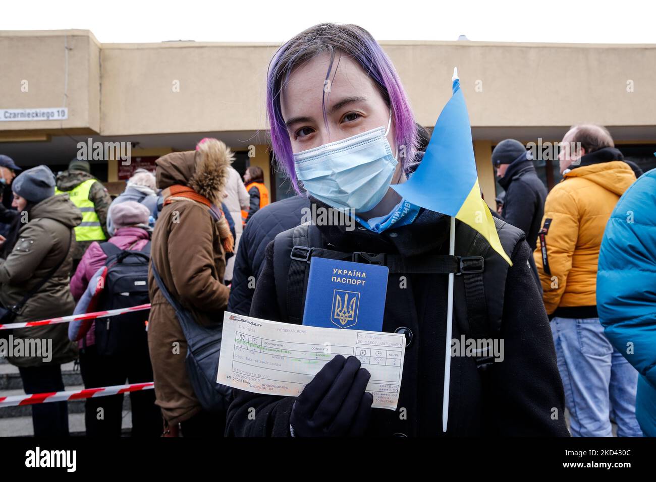 Eine junge ukrainische Frau mit ihrem Pass, ihrer Nationalflagge und einer Schlange für Zugtickets, um von Przemysl, Polen, aus in einen Zug nach Lemberg zu steigen, wie viele Ukrainer, einschließlich Frauen, beschlossen, in ihr Land zurückzukehren, um ihre Familie vor der russischen Invasion zu bekämpfen und zu unterstützen - 2. März 2022. Sie sagt, sie geht, um für ihr Land zu kämpfen. Da die Armee der Russischen Föderation die ukrainischen Grenzen überschritten hat, wird der Konflikt zwischen der Ukraine und Russland voraussichtlich bis zu 4 Millionen Ukrainer zur Flucht zwingen. Die russische Armee wurde von der ukrainischen Armee und den Zivilpersonen mit heftiger Opposition konfrontiert. (Foto von Dominika Zarzycka/NurPhoto) Stockfoto