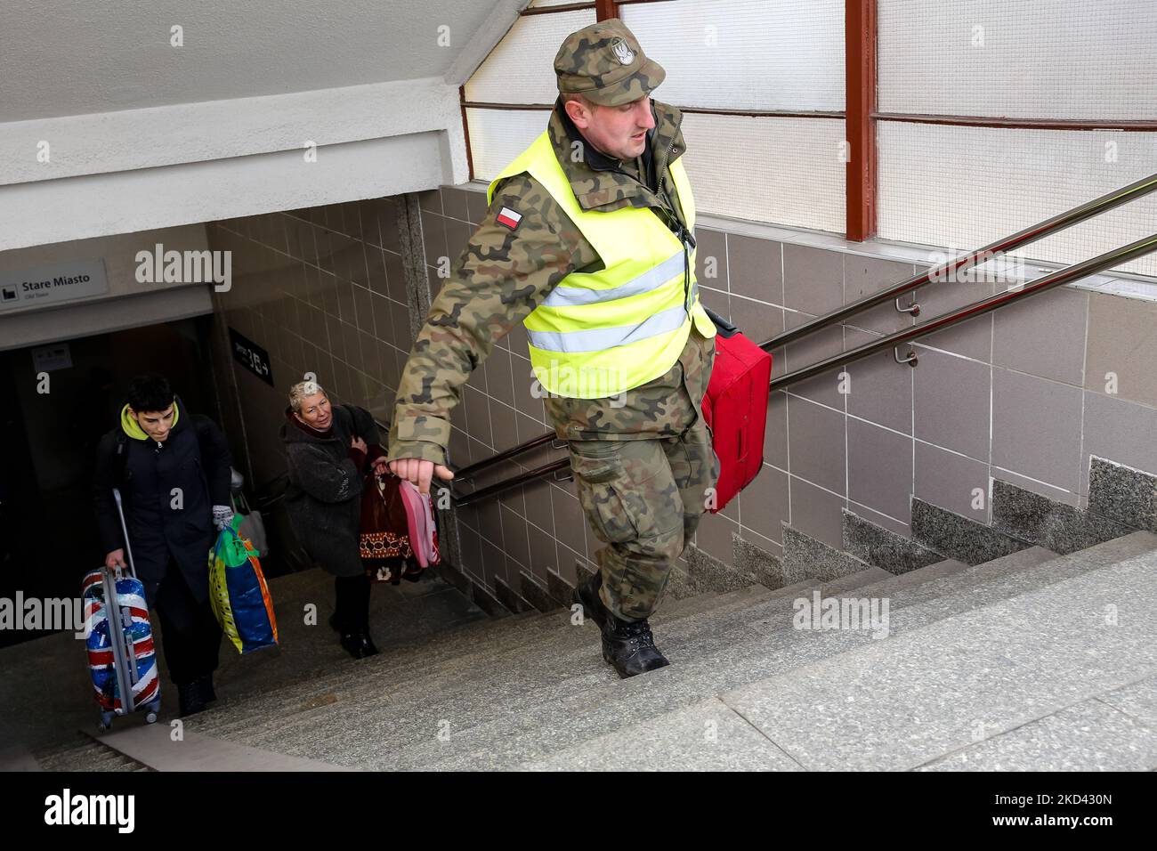 Ein polnischer Militärangehöriger hilft einer ukrainischen Familie, ihr Gepäck bei der Ankunft am Bahnhof in Przemysl, Polen, zu tragen, da bereits mehr als 300 000 Menschen infolge der russischen Invasion in die Ukraine flohen – am 2. März 2022. Da die Armee der Russischen Föderation die ukrainischen Grenzen überschritten hat, wird der Konflikt zwischen der Ukraine und Russland voraussichtlich bis zu 4 Millionen Ukrainer zur Flucht zwingen. Viele der Flüchtlinge werden in Polen Asyl beantragen. Die meisten Flüchtlinge kamen in Grenzstädte wie Przemysl an und werden in Innenstädte verlegt. (Foto von Dominika Zarzycka/NurPhoto) Stockfoto
