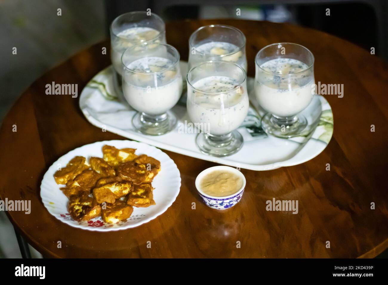 Apfelshake serviert mit indischem Hüttenkäse Pakoda am Couchtisch für die Heimparty Stockfoto
