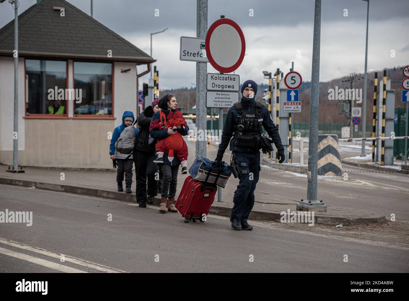 Ein Polizist hilft Ukrainern, ihre Tasche am 5. März 2022 an der Grenze in Krosienko, Polen, zu tragen. Mehr als 1 Millionen Flüchtlinge fliehen seit der russischen Invasion in einer Woche aus der Ukraine. Während der Konflikt andauert, fliehen die Kriegsflüchtlinge aus ihrer Heimatstadt, erreichen die Grenze zu Polen, um Zugang zur Europäischen Union zu erhalten. (Foto von Enrico Mattia Del Punta/NurPhoto) Stockfoto