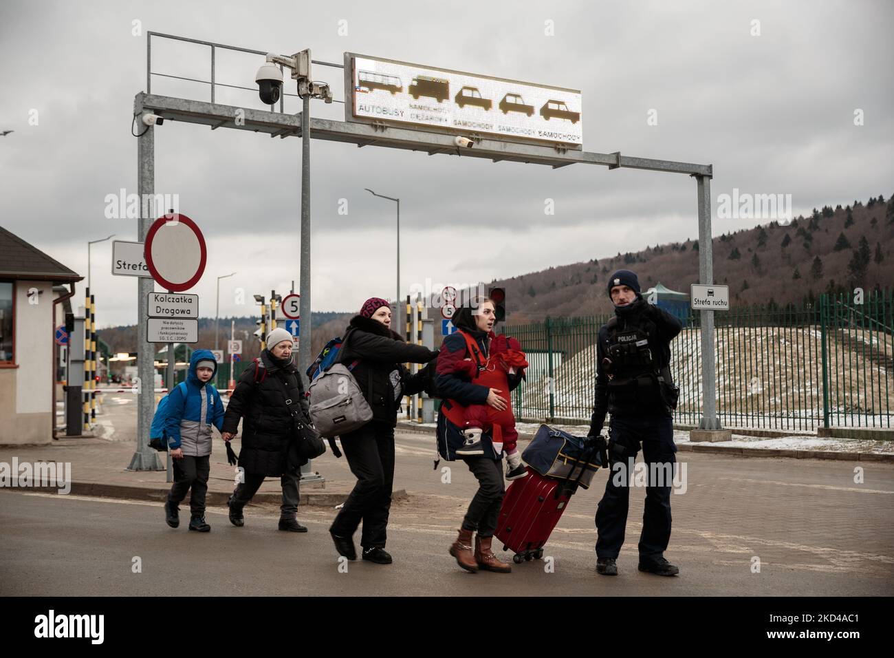 Ein Polizist hilft Ukrainern, ihre Tasche am 5. März 2022 an der Grenze in Krosienko, Polen, zu tragen. Mehr als 1 Millionen Flüchtlinge fliehen seit der russischen Invasion in einer Woche aus der Ukraine. Während der Konflikt andauert, fliehen die Kriegsflüchtlinge aus ihrer Heimatstadt, erreichen die Grenze zu Polen, um Zugang zur Europäischen Union zu erhalten. (Foto von Enrico Mattia Del Punta/NurPhoto) Stockfoto
