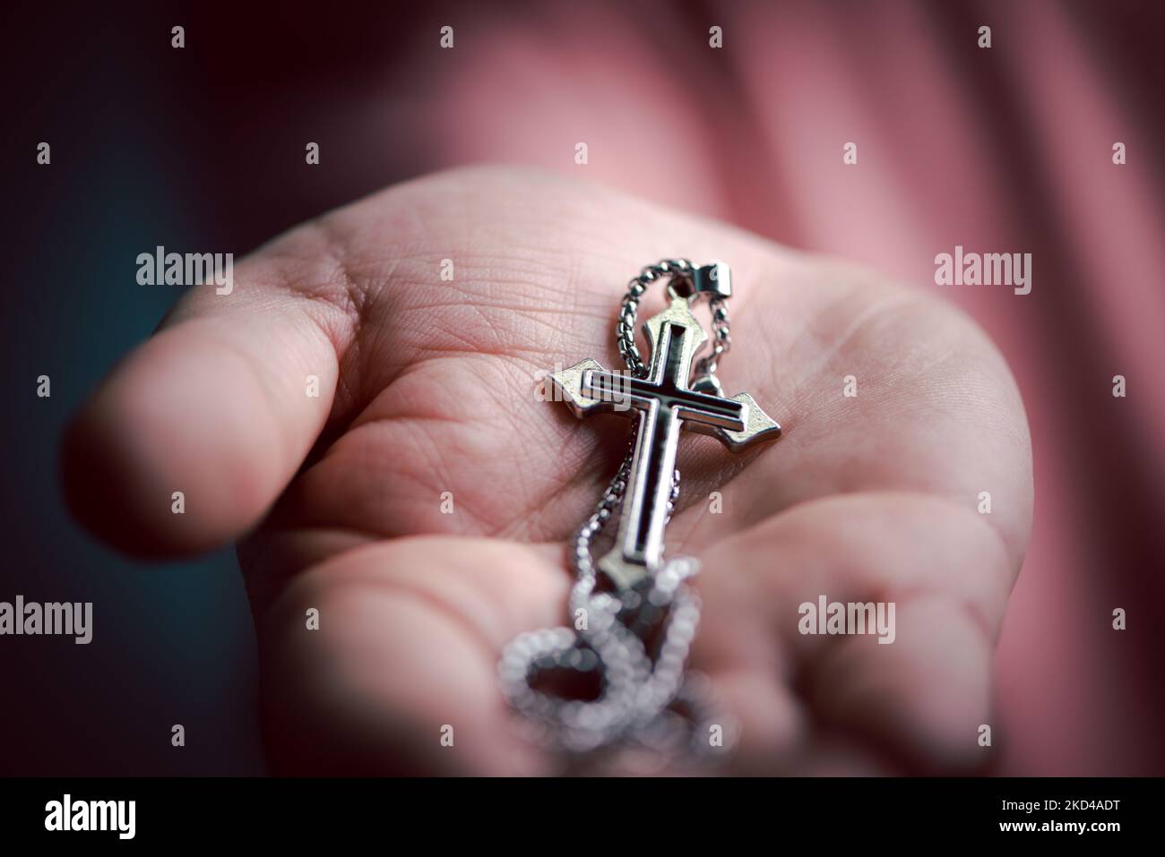 Geistliche christliche Hand, die Jesus Kreuz Halskette in der Handfläche mit Glauben und Glauben hält. Stockfoto