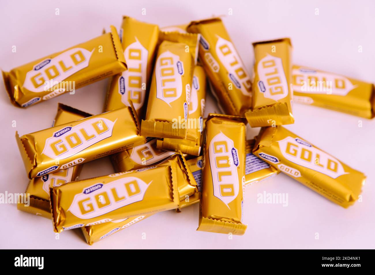 Stapel von McVities Gold-Riegel in grobem Stapel - mehrere goldene Schokoladen-Riegel als Snack-Leckerbissen Stockfoto