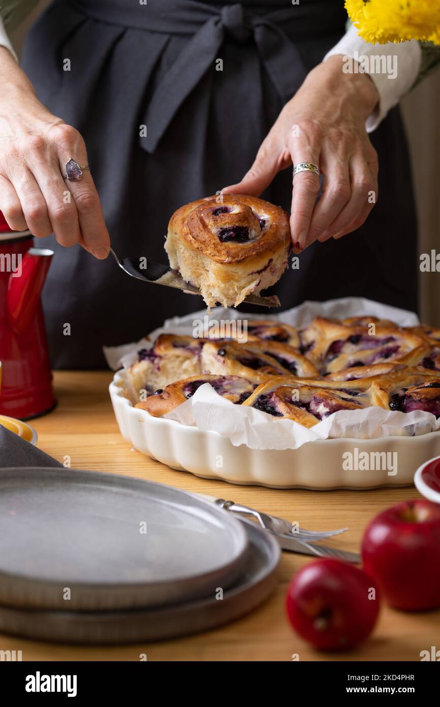 Mädchen in einer Schürze Mädchen auslegen cinnabon Brötchen mit ...