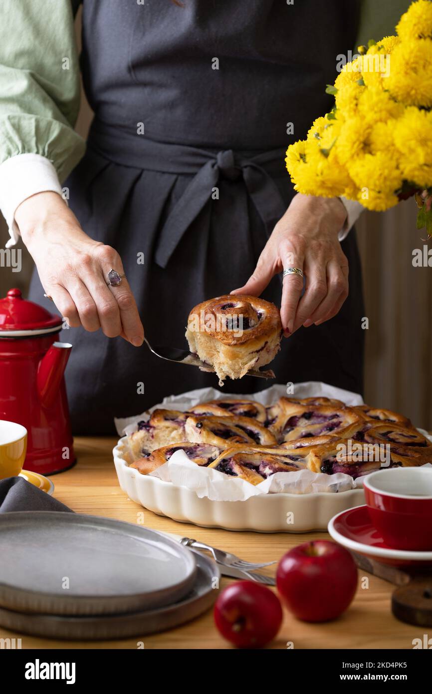Mädchen in einer Schürze Mädchen auslegen cinnabon Brötchen mit ...
