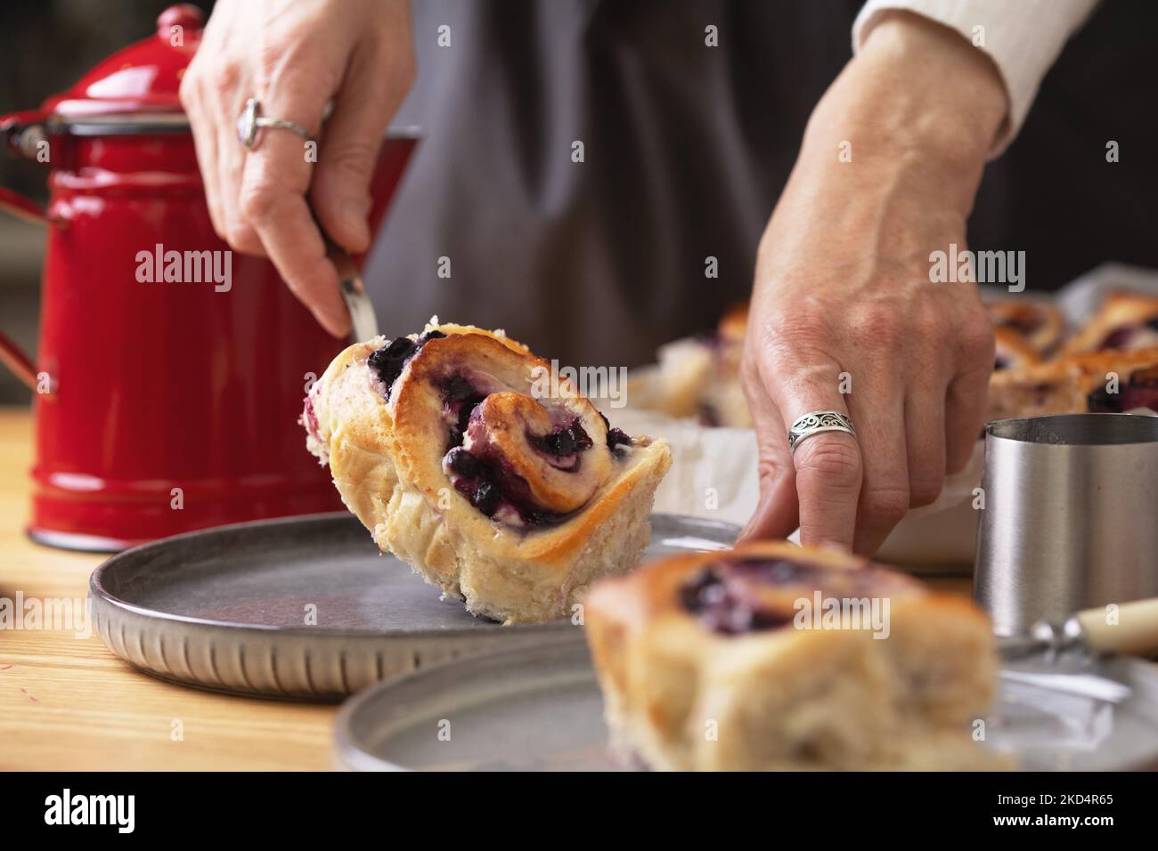 Mädchen in einer Schürze Mädchen auslegen cinnabon Brötchen mit ...