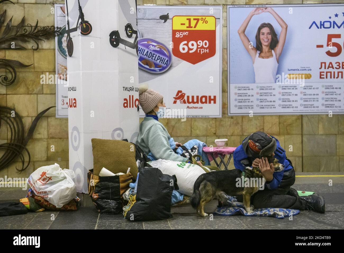 Menschen mit Hund auf einer der U-Bahnstationen, die während einer Bombendrohung in Kiew, Ukraine, als Bombenschutzraum genutzt wurden. 9. März 2022 (Foto: Maxym Marusenko/NurPhoto) Stockfoto