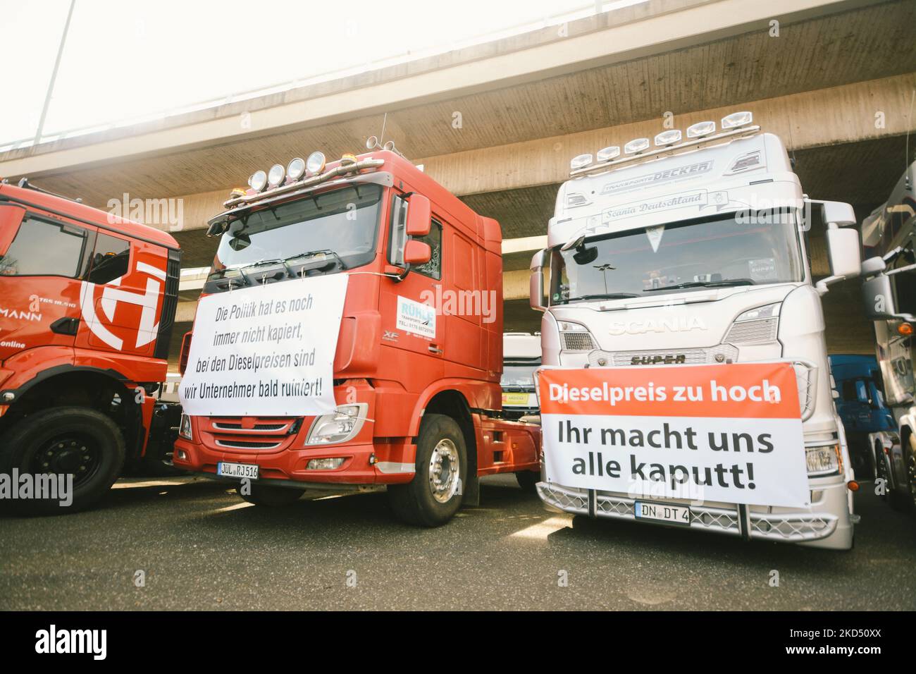 Banner mit „ “ Dieselpreis ist zu hoch, du ruinst uns „ “ hängen vor Truckern während der Demo von 500 Truckern vor dem Parkplatz des Kölner Messegeländes gegen den hohen Kraftstoffpreis in Köln am 12. März 2022 (Foto: Ying Tang/NurPhoto) Stockfoto