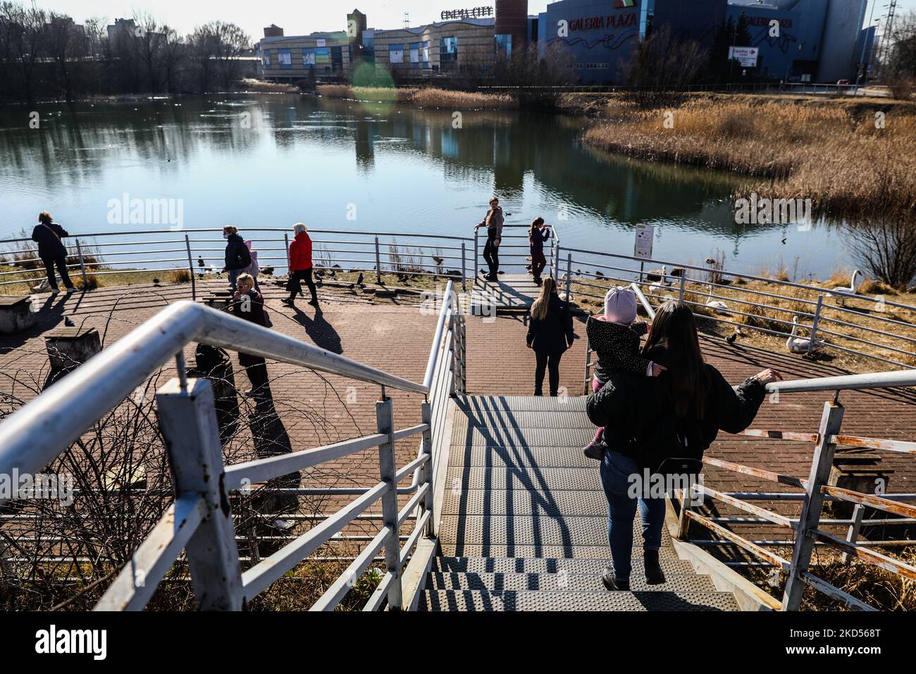 Flüchtlinge aus der Ukraine, die aufgrund der andauernden russischen Militärinvasion die ukrainisch-polnische Grenze überschritten haben, werden im Freien an einem Teich neben einem Tierheim und dem Empfangsort gesehen, der am 14. März 2022 in einem ehemaligen Gebäude des Einkaufszentrums „Plaza“ in Krakau, Polen, organisiert wurde. Die russische Invasion in der Ukraine führt zu einer Massenflucht von Flüchtlingen nach Polen. (Foto von Beata Zawrzel/NurPhoto) Stockfoto