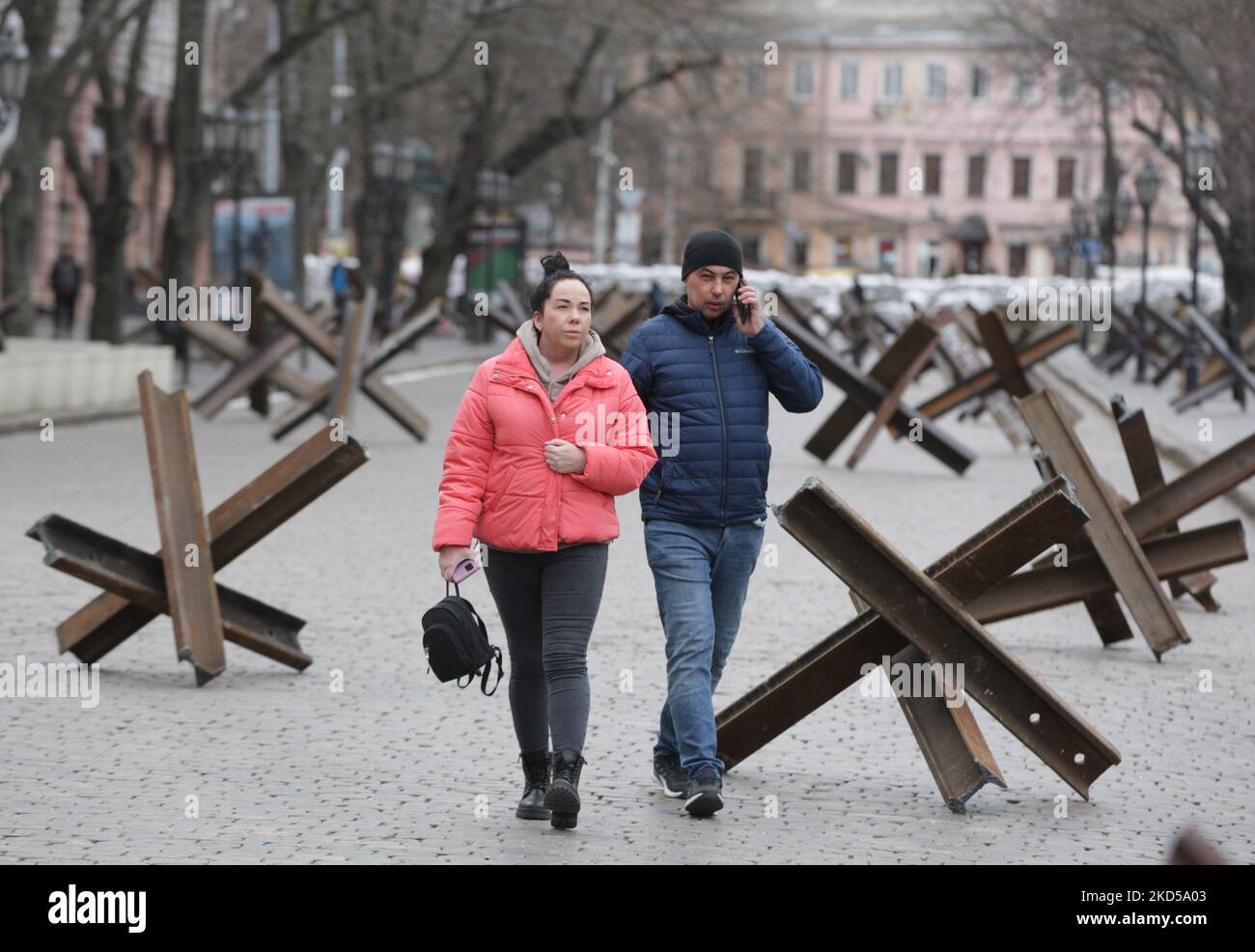 Ukrainer gehen nach dem Beginn der russischen Invasion während des Ukraine-Russland-Kriegs im Zentrum der Stadt Odesa, Ukraine, am 16. März 2022 an Panzerschutzhemmnissen vorbei. (Foto von STR/NurPhoto) Stockfoto