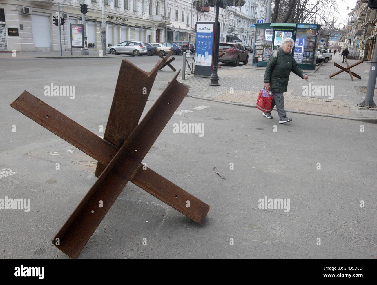 Eine Frau geht nach dem Beginn der russischen Invasion während des Ukraine-Russland-Krieges im Zentrum der Stadt Odesa, Ukraine, am 18. März 2022, an Panzerschutzhemmnissen vorbei. (Foto von STR/NurPhoto) Stockfoto