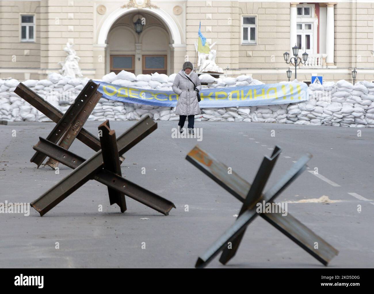 Eine Frau geht nach dem Beginn der russischen Invasion während des Ukraine-Russland-Krieges im Zentrum der Stadt Odesa, Ukraine, am 18. März 2022, an Panzerschutzhemmnissen vorbei. (Foto von STR/NurPhoto) Stockfoto