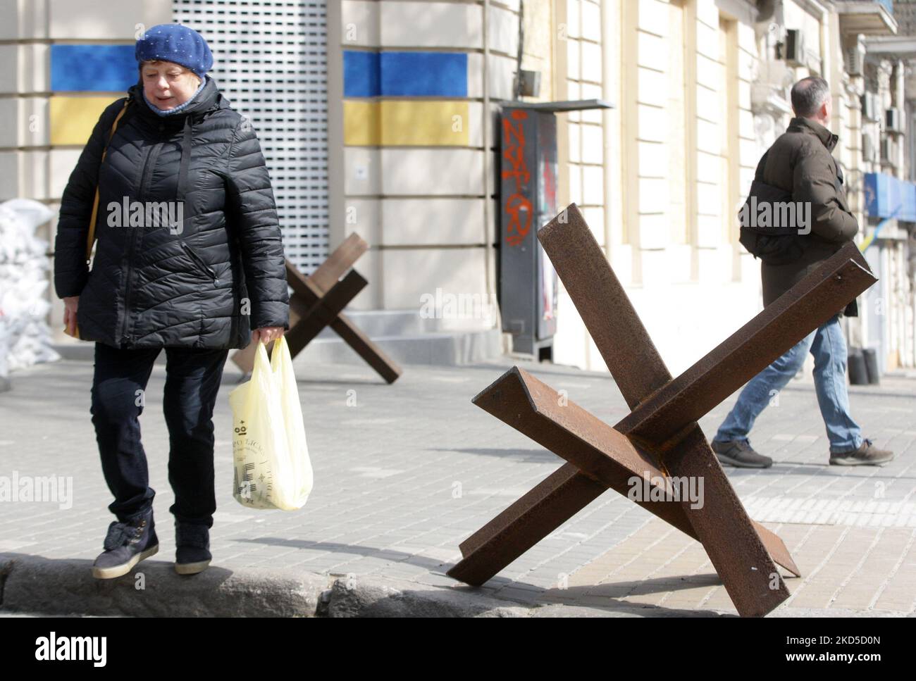 Eine Frau geht nach dem Beginn der russischen Invasion während des Ukraine-Russland-Krieges im Zentrum der Stadt Odesa, Ukraine, am 18. März 2022, an Panzerschutzhemmnissen vorbei. (Foto von STR/NurPhoto) Stockfoto