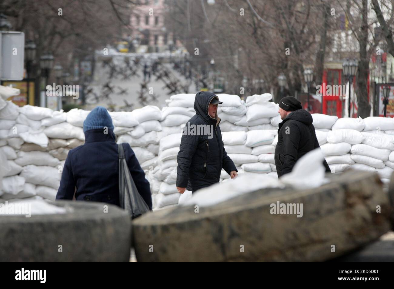 Ukrainer gehen nach dem Beginn der russischen Invasion während des Ukraine-Russland-Krieges im Zentrum der Stadt Odesa, Ukraine, am 18. März 2022, an Panzerschutzhemmnissen vorbei. (Foto von STR/NurPhoto) Stockfoto