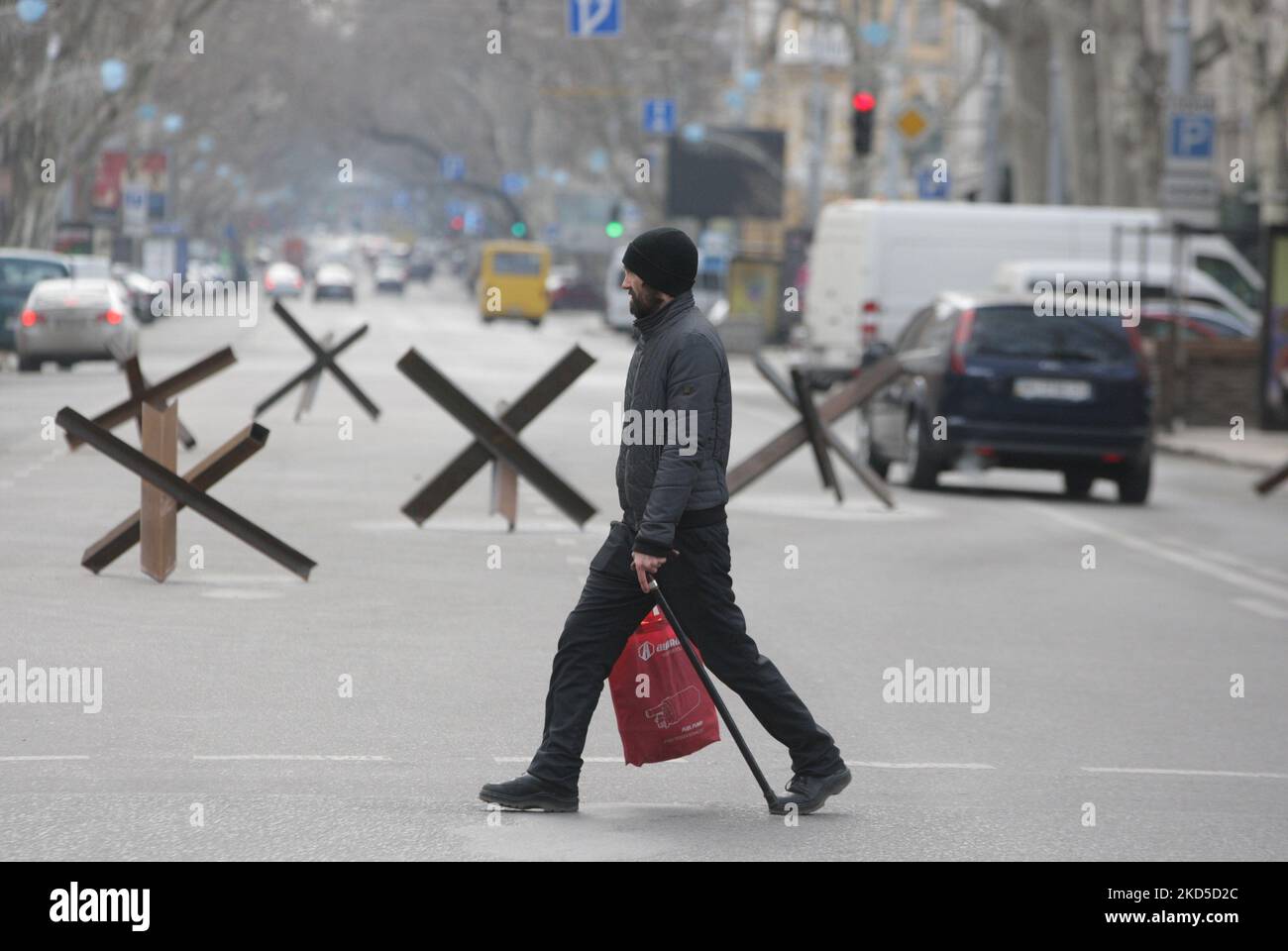 Ein Mann geht nach dem Beginn der russischen Invasion während des Ukraine-Russland-Krieges im Zentrum der Stadt Odesa, Ukraine, am 18. März 2022, an Panzerschutzhemmnissen vorbei. (Foto von STR/NurPhoto) Stockfoto