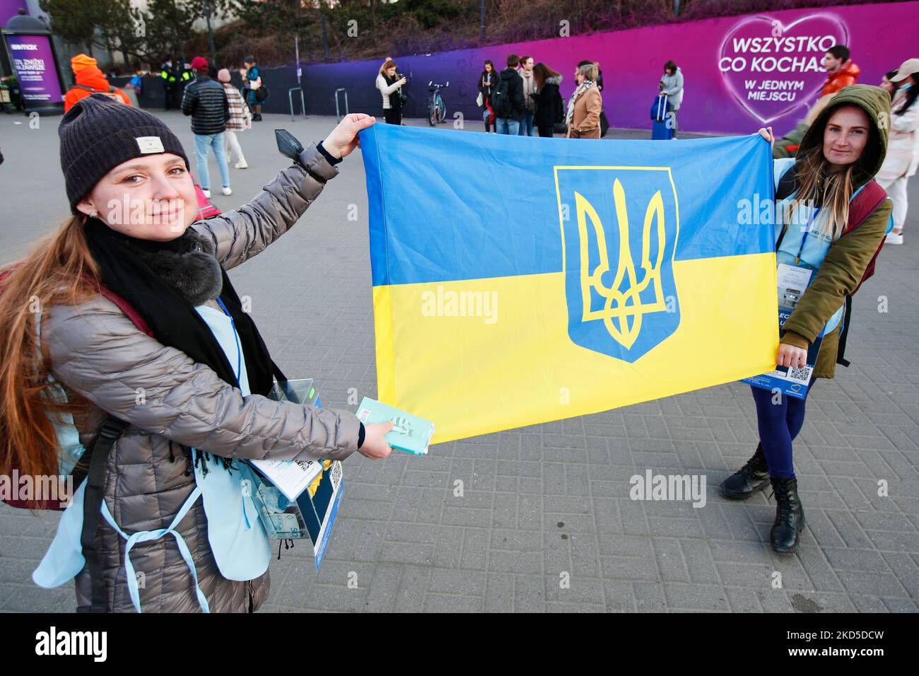 Natalija (links) und ein Freund aus Kiew halten am 18. März 2022 in der Nähe des Hauptbahnhofs in Warschau, Polen, eine ukrainische Flagge, als sie Gelder sammeln, um Ukrainern zu helfen. Polen hat seit dem 24. Februar 2022 mehr als 1,5 Millionen Flüchtlinge aufgenommen, die vor der russischen Invasion ihres Landes fliehen mussten. Allein in Warschau ist die Bevölkerung durch den Zustrom von Flüchtlingen um fast 20 Prozent gewachsen. Der Druck auf die Ressourcen hat den Bürgermeister von Warschau, Rafal Trzaskowski, veranlasst, Unterstützung von der EU und den Vereinten Nationen zu fordern. (Foto von STR/NurPhoto) Stockfoto