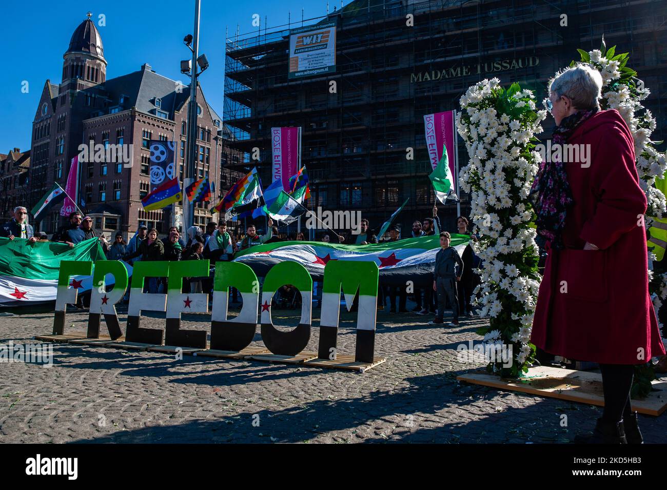 Eine Frau blickt auf das Wort FREIHEIT und die weißen Blumen, die die elf Jahre der syrischen Revolution darstellen, die am 19.. März 2022 in Amsterdam organisiert wurde. (Foto von Romy Arroyo Fernandez/NurPhoto) Stockfoto