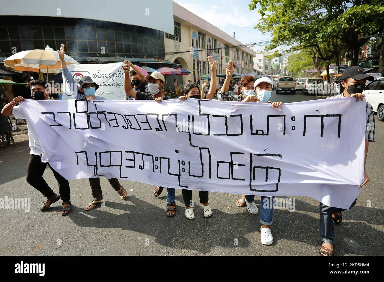 Eine Gruppe junger Demonstranten ruft slogansÂ und grüßt den trotzigen Dreifinger, als sie während einer Demonstration gegen den Militärputsch in der Nähe der Shwedagon-Pagode in Yangon, Myanmar, am 20. März 2022 marschieren. (Foto von Myat Thu Kyaw/NurPhoto) Stockfoto