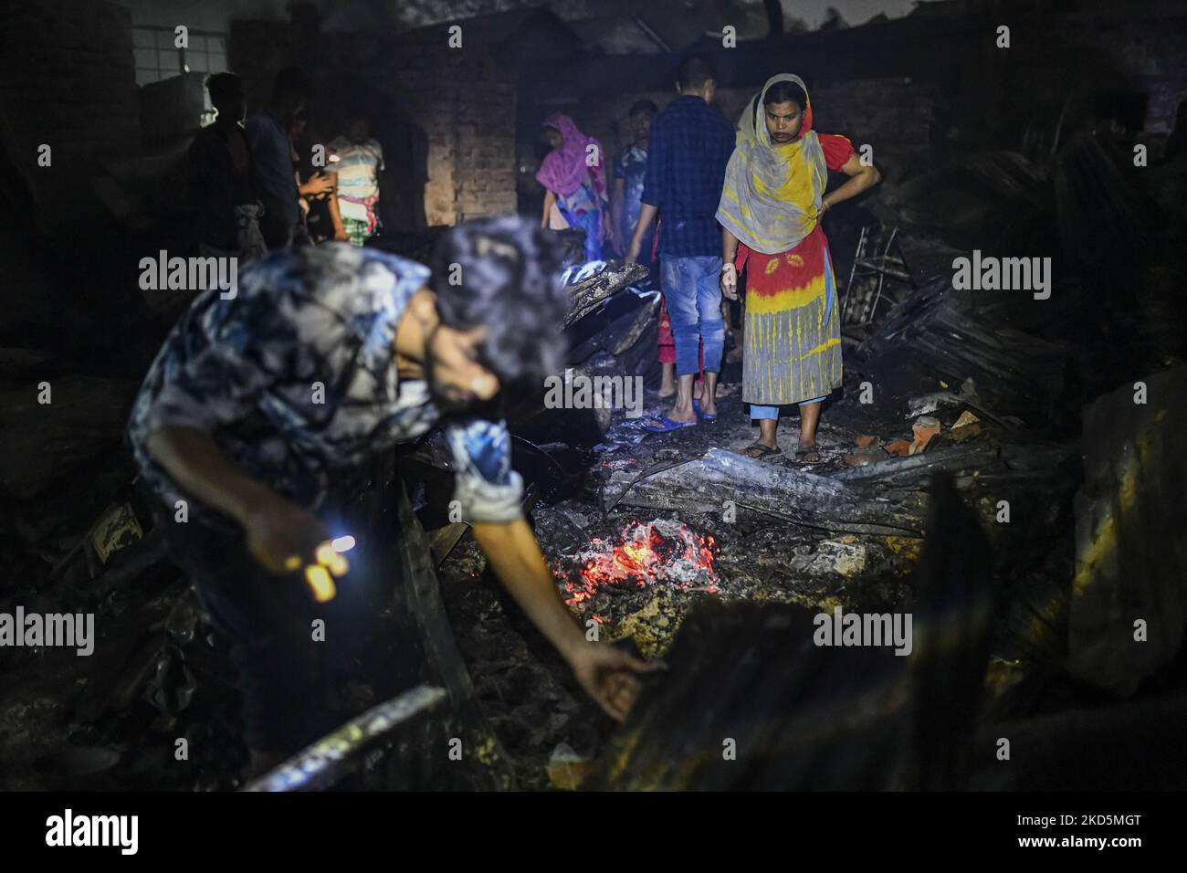 Slumbewohner suchen nach ihren Habseligkeiten aus der Asche, die am 20. März 2022 durch das massive Feuer im Slum Beltola im Gebiet Notunbazar bei Kallayanpur in Dhaka, Bangladesch, verursacht wurde. (Foto von Zabed Hasnain Chowdhury/NurPhoto) Stockfoto