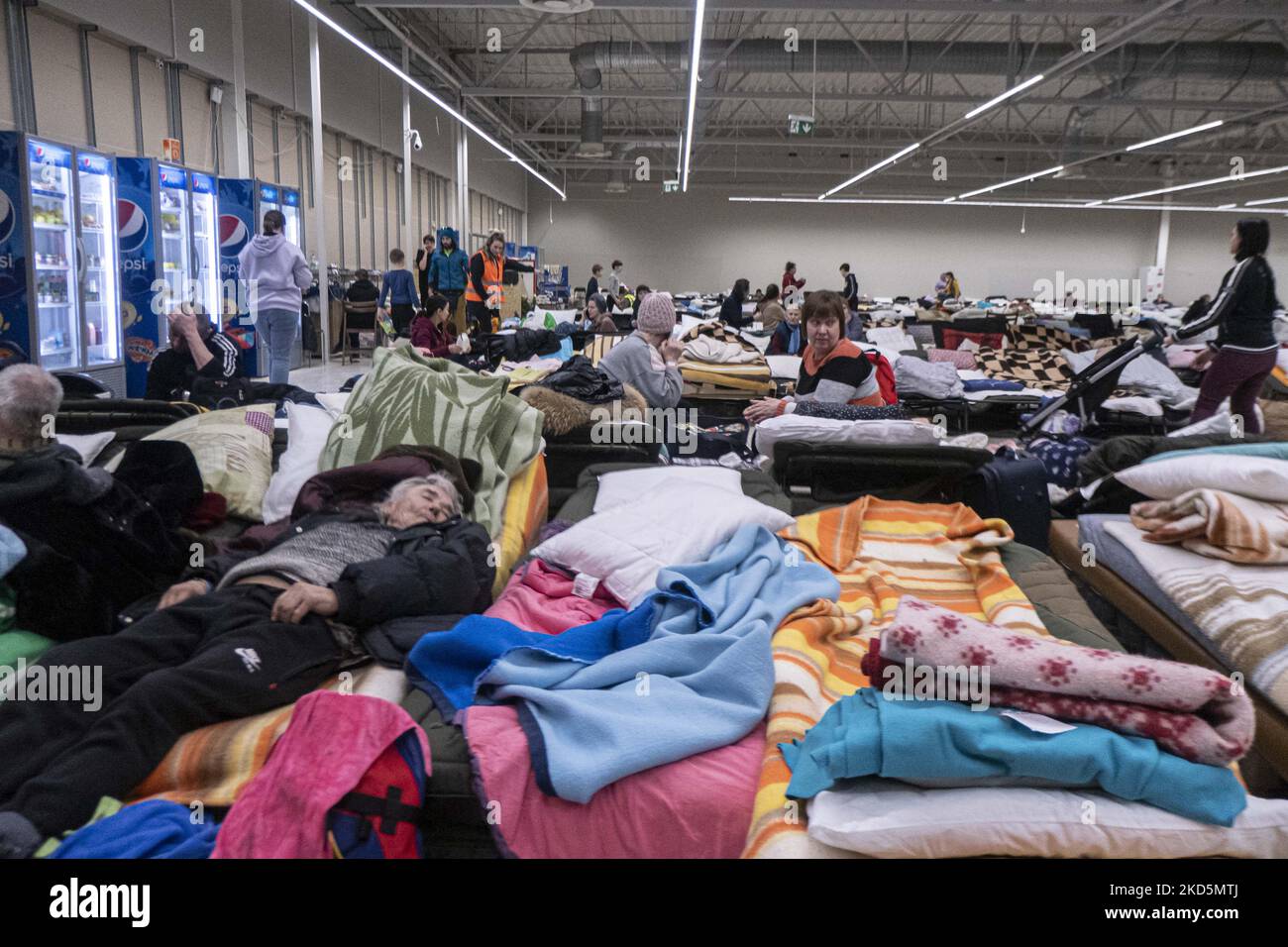 Temporärer Schlafbereich mit Campingbetten und Matratzen für Menschen im ehemaligen Einkaufszentrum. Das temporäre Zentrum für humanitäre Hilfe in Przemysl, einer Stadt 10km aus der Ukraine und dem Grenzübergang Medyka Shehyni. Das humanitäre Zentrum war ein ehemaliges Einkaufszentrum, das von Freiwilligen, Wohltätigkeitsorganisationen, NGOs, den lokalen Behörden und den polnischen Streitkräften in das größte Hilfszentrum der Region umgewandelt wurde. Ukrainische Flüchtlinge können Unterkunft, Schlaf, medizinische Hilfe, Nahrung finden, sich registrieren und ihren Transport für die Umsiedlung nach Europa oder Polen organisieren. Nach Angaben der UN - UNHCR mehr als 3,3 m Stockfoto