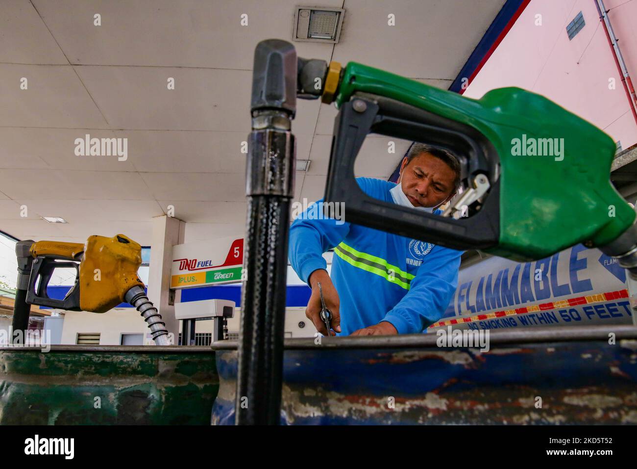 Ein Arbeiter pumpt am 22. März 2022 an einer Tankstelle in Mandaluyong City, östlich von Manila, Philippinen, Kraftstoff in mehrere Fässer. (Foto von George Calvelo/NurPhoto) Stockfoto