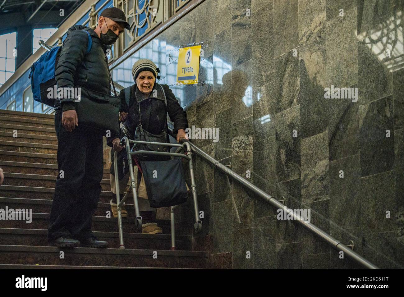 Der alte ukrainische Flüchtling geht mit Hilfe´s Hauptbahnhofs von Lviv die Treppe hinunter, um den Zusammenstößen während des Russlandkrieges in der Ukraine zu entkommen. (Foto von Celestino Arce/NurPhoto) Stockfoto