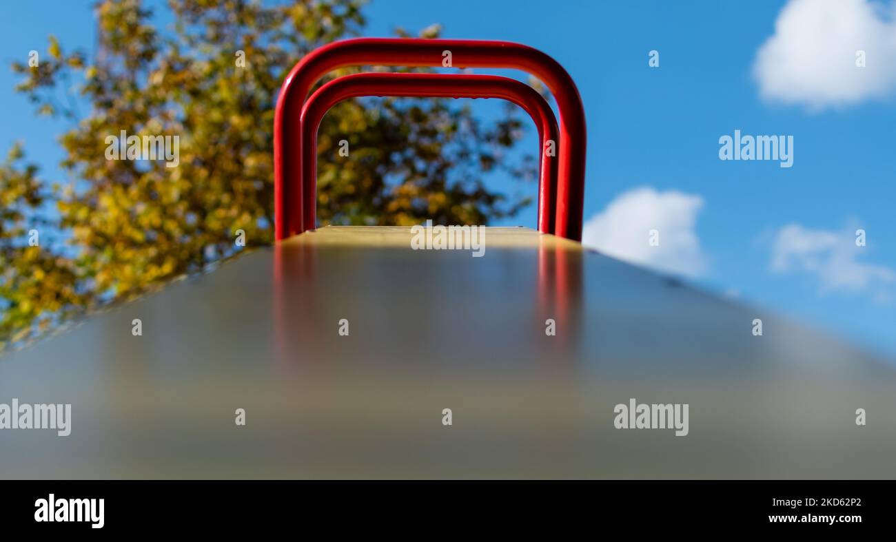 Metallstrukturen der Anziehungskraft für Kinder auf dem Spielplatz auf unscharfem Hintergrund des blauen Himmels Stockfoto