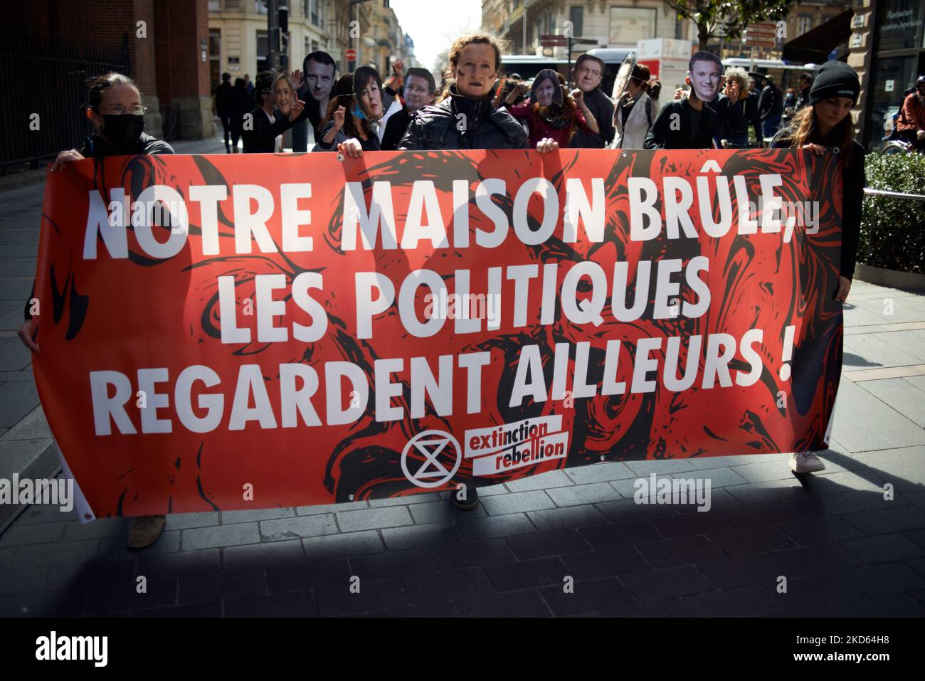 Auf dem Transparent steht: „Unser Haus brennt, und die Politiker schauen woanders hin“. XR (Extinction Rebellion) organisierte in Toulouse ein Ereignis, um die französischen Präsidentschaftskandidaten aufzufordern, die Klimanotlage, die im politischen Wahlkampf fast nicht vorhanden ist, zu berücksichtigen. Das Thema lautete: „Unser Haus brennt, und Politiker schauen woanders hin“. Dafür waren einige rot getanzt, andere verkleidet mit Schwangeren, um den Tod künftiger Generationen aufgrund der globalen Erwärmung und des Einbruchs der Umwelteinbussen zu symbolisieren.Sie haben auch vor dem Rathaus von Toulouse einen Einfall gemacht. Toulouse. Frankreich. Stockfoto