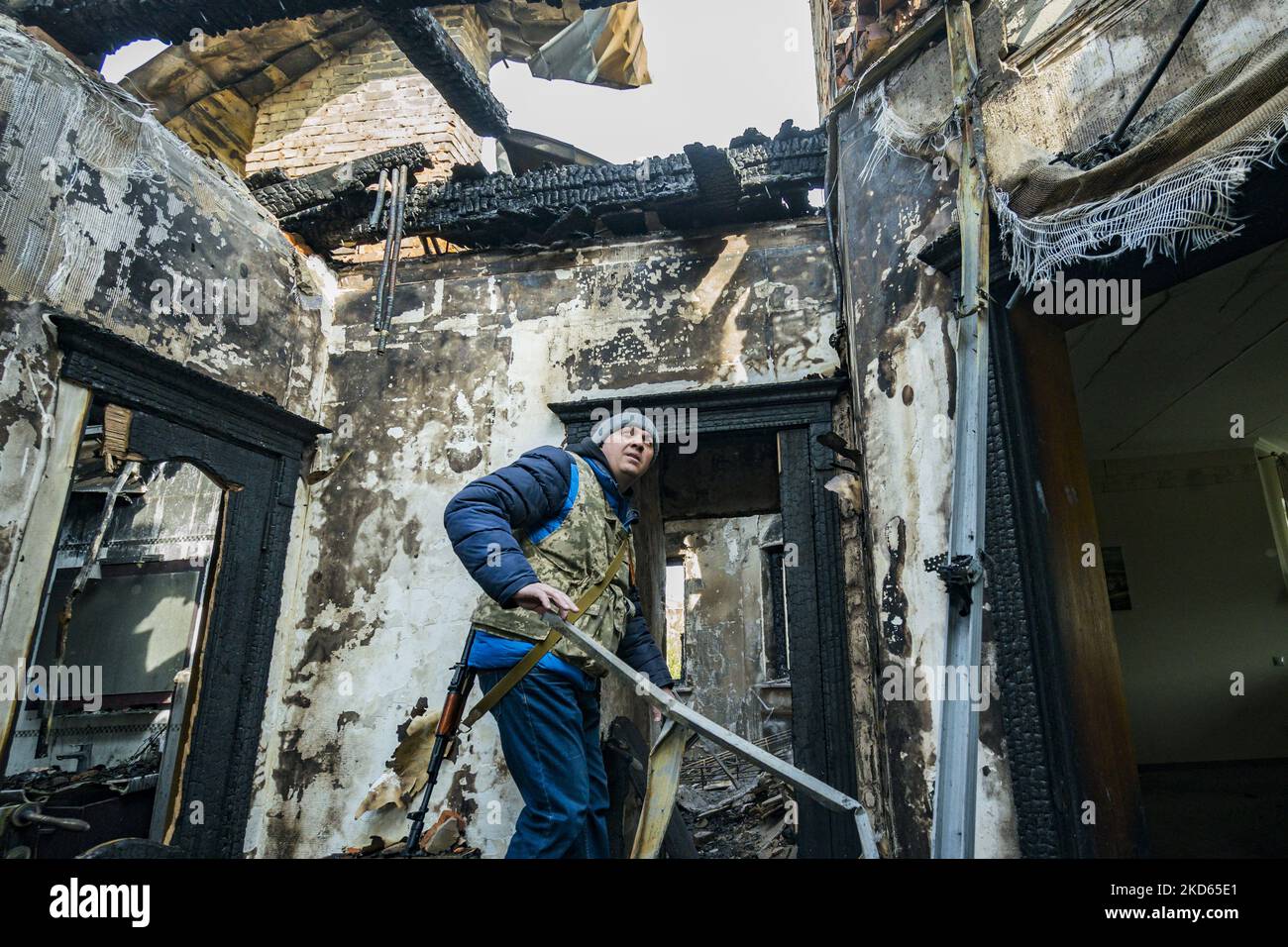 Ukrainischer Milizist in den Ruinen eines vom Feuer verbrannten Hauses nach den Angriffen der russischen Artillerie auf das Dorf Yasnohorodka am Stadtrand von Kiew. (Foto von Celestino Arce/NurPhoto) Stockfoto