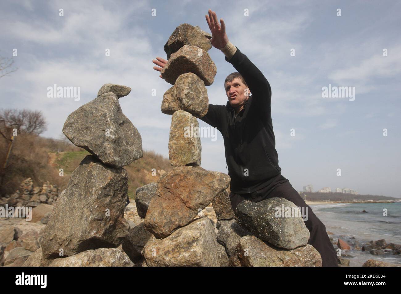 Alexander Izman (49 Jahre alt) schafft ein improvisiertes Kunstobjekt aus Steinen namens Rock Garden am Strand der Stadt Odesa, Ukraine. Der örtliche Alexander Izman kommt zwei Jahre lang an den Strand von Odesa, um Steinskulpturen zu schaffen. Einige der Steine wiegen bis zu 30 kg. Es ist ziemlich schwierig, die Konfiguration, Form, Gewicht und das Gleichgewicht der Steine zu wählen, aber die Energie hat sich hier verändert und einige Leute kommen und meditieren hier, sagt er. (Foto von STR/NurPhoto) Stockfoto