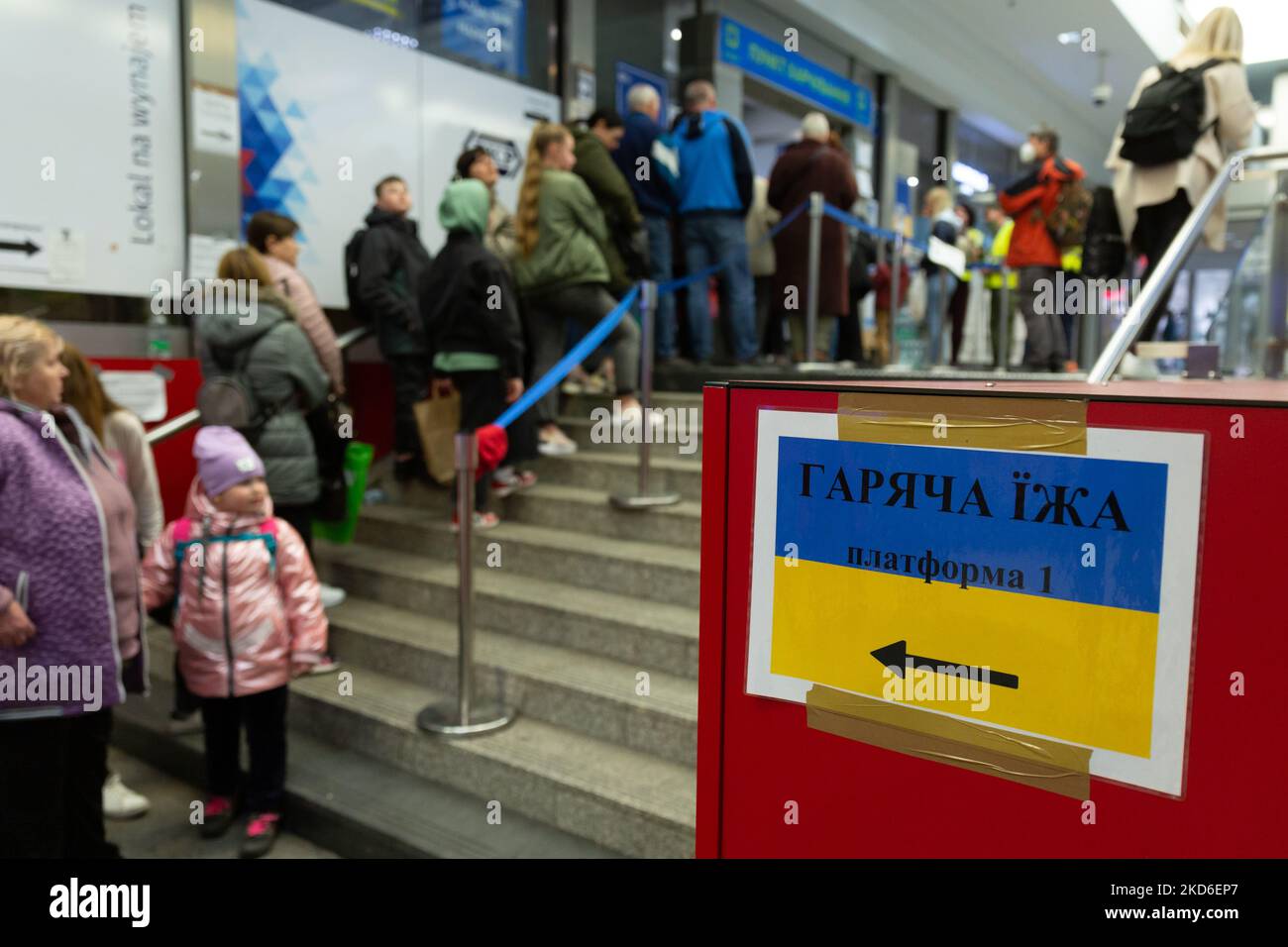 Ukrainische Flüchtlinge stehen Schlange, um von der humanitären Hilfe am Hauptbahnhof in Krakau, Polen, warme Speisen zu erhalten, da viele polnische Menschen freiwillig Hilfe für kriegsgeplagte Flüchtlinge leisten, da bereits mehr als zwei Millionen Menschen aus der Ukraine nach Polen geflohen sind - am 1. April 2022. Während die Russische Föderation in die Ukraine einmarschierte, wird der Konflikt zwischen der Ukraine und Russland voraussichtlich bis zu 5 Millionen Ukrainer zur Flucht zwingen. Viele der Flüchtlinge suchen in Polen Asyl. Die meisten karitativen Hilfen in Polen werden von Einzelpersonen, NGOs und Unternehmen geleistet. Die Entkommenen werden oft von i aufgenommen Stockfoto