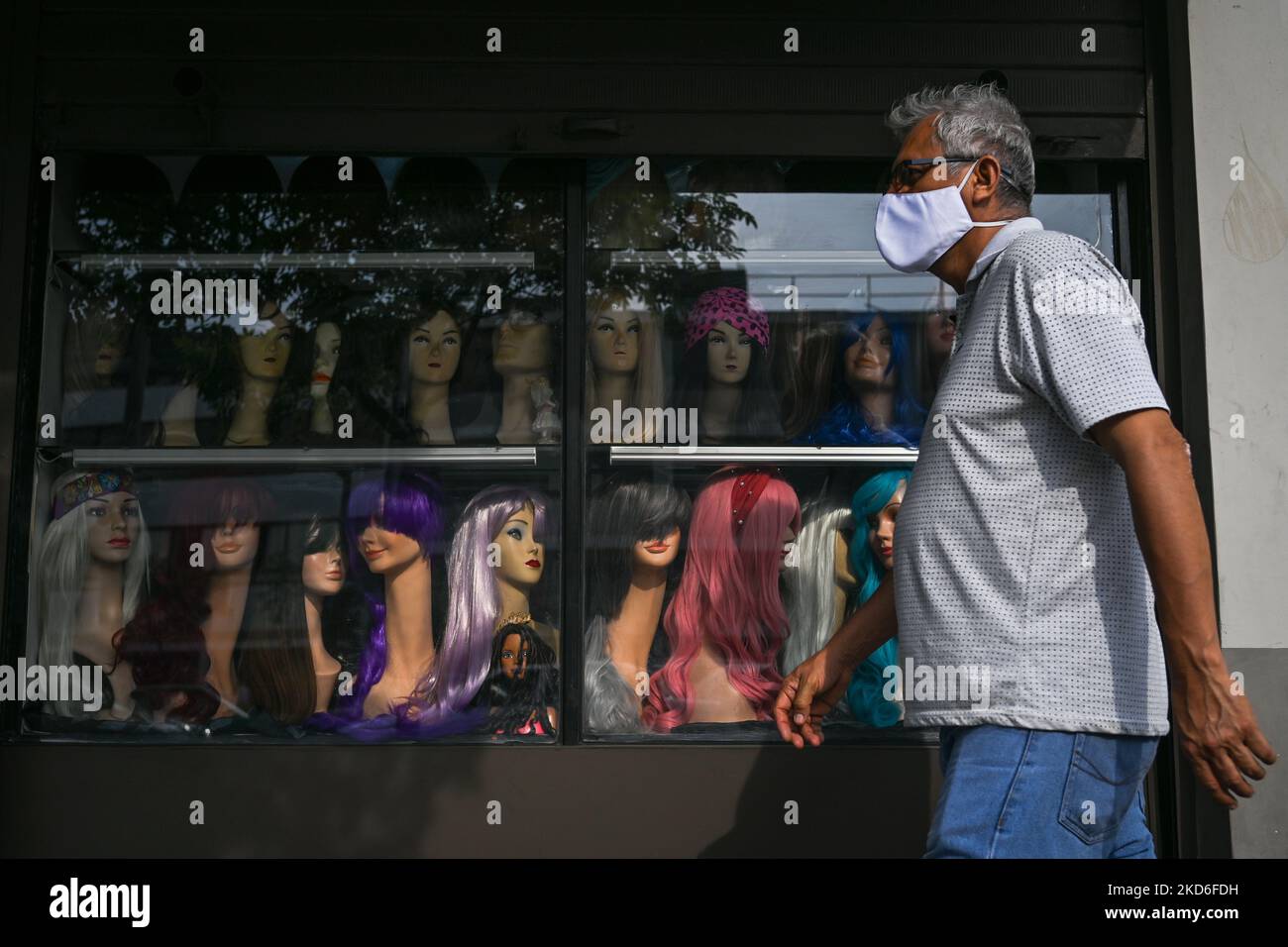 Ein Mann mit Gesichtsmaske kommt an einem Geschäft mit Perücken im Stadtzentrum von Lima vorbei. Am Freitag, den 01. April 2022, in Lima, Peru. (Foto von Artur Widak/NurPhoto) Stockfoto