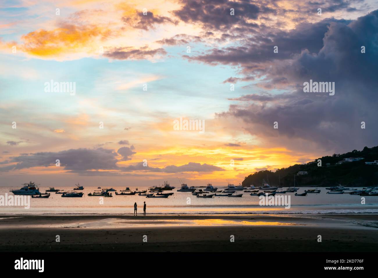 Ein strahlender Sonnenuntergang Himmel über dem Wasser mit Booten in San Juan del Sur, Nicaragua Stockfoto