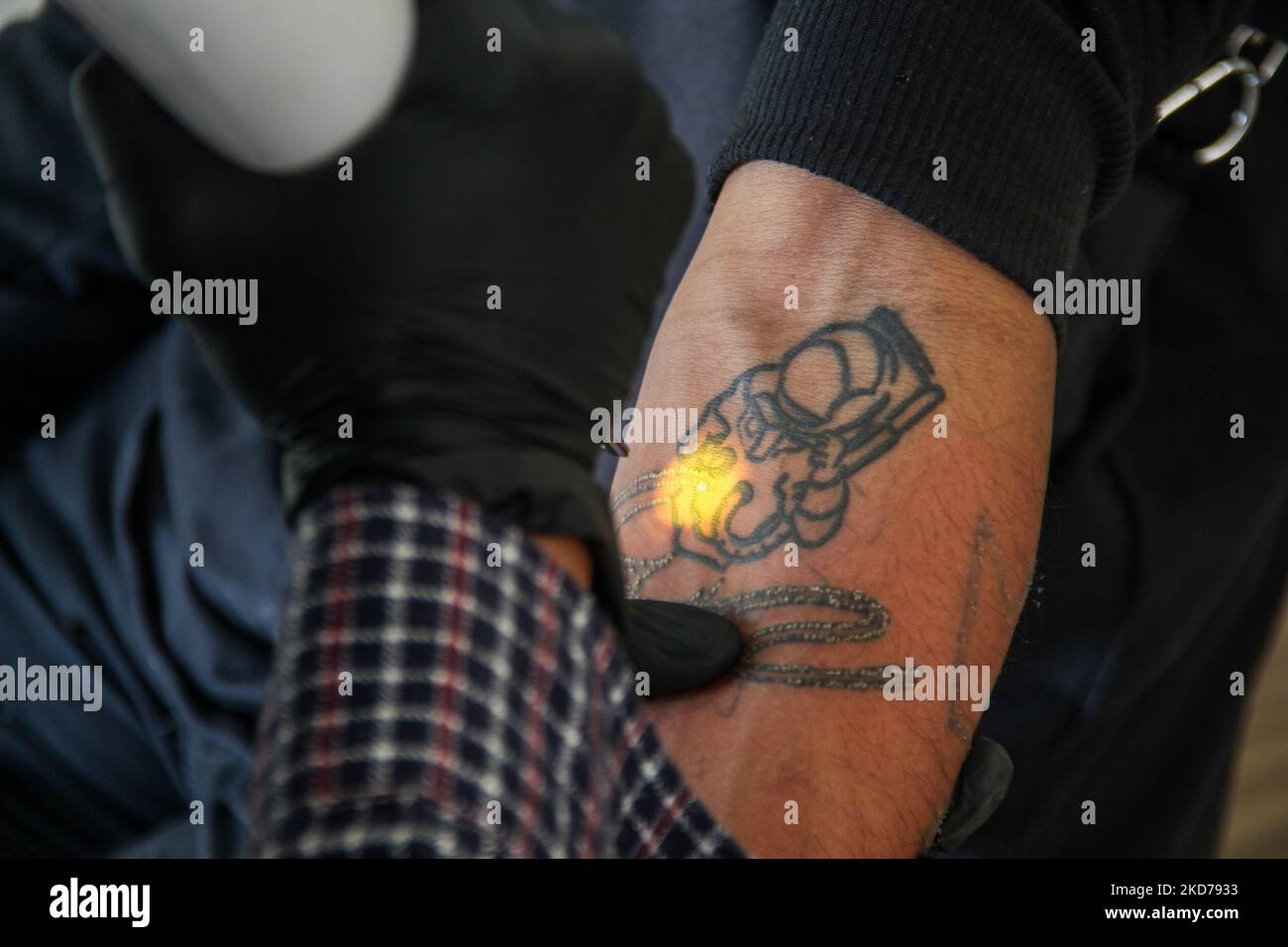 Denny Kurniawan von Hijrah Care sieht, wie sie die Tattoos der Teilnehmer mit einem Lasergerät während eines kostenlosen Tätowierungsprogramms am 10. April 2022 in der Al Latiif Moschee, Bandung City, Indonesien, entfernt. Im Heiligen Monat Ramadan veranstaltete Hijrah Care in Zusammenarbeit mit dem Familienrat der Al Latiif Moschee (DKM) ein kostenloses Tätowierungsprogramm mit insgesamt rund 40 Teilnehmern. (Foto von Algi Febri Sugita/NurPhoto) Stockfoto