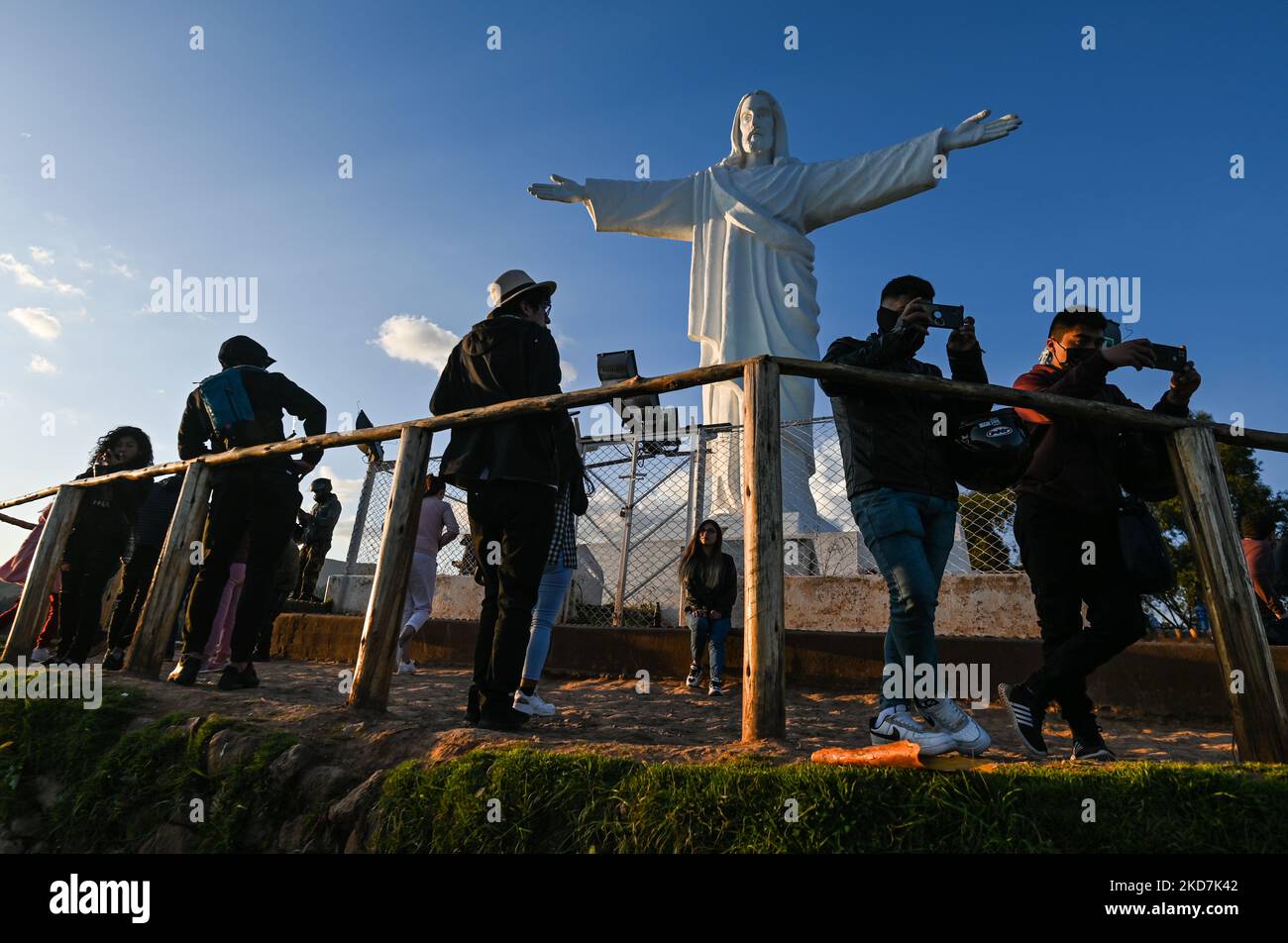 Einheimische, Besucher und Touristen auf dem Hügel neben Cristo Blanco, einer großen Statue von Jesus Christus mit Blick auf die Stadt Cusco. Der Gründonnerstag ist ein Tag frei für viele Einwohner von Cusco, die mit ihren Familien Orte besuchen, die mit der Tradition der Karwoche in Verbindung stehen. Am Donnerstag, den 14. April 2022, in Cusco, Peru. (Foto von Artur Widak/NurPhoto) Stockfoto
