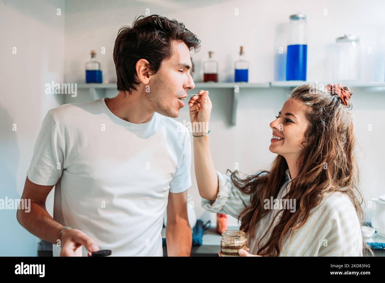 Freundin füttert ihren Freund mit Tiramisu-Creme. Morgens Stockfoto