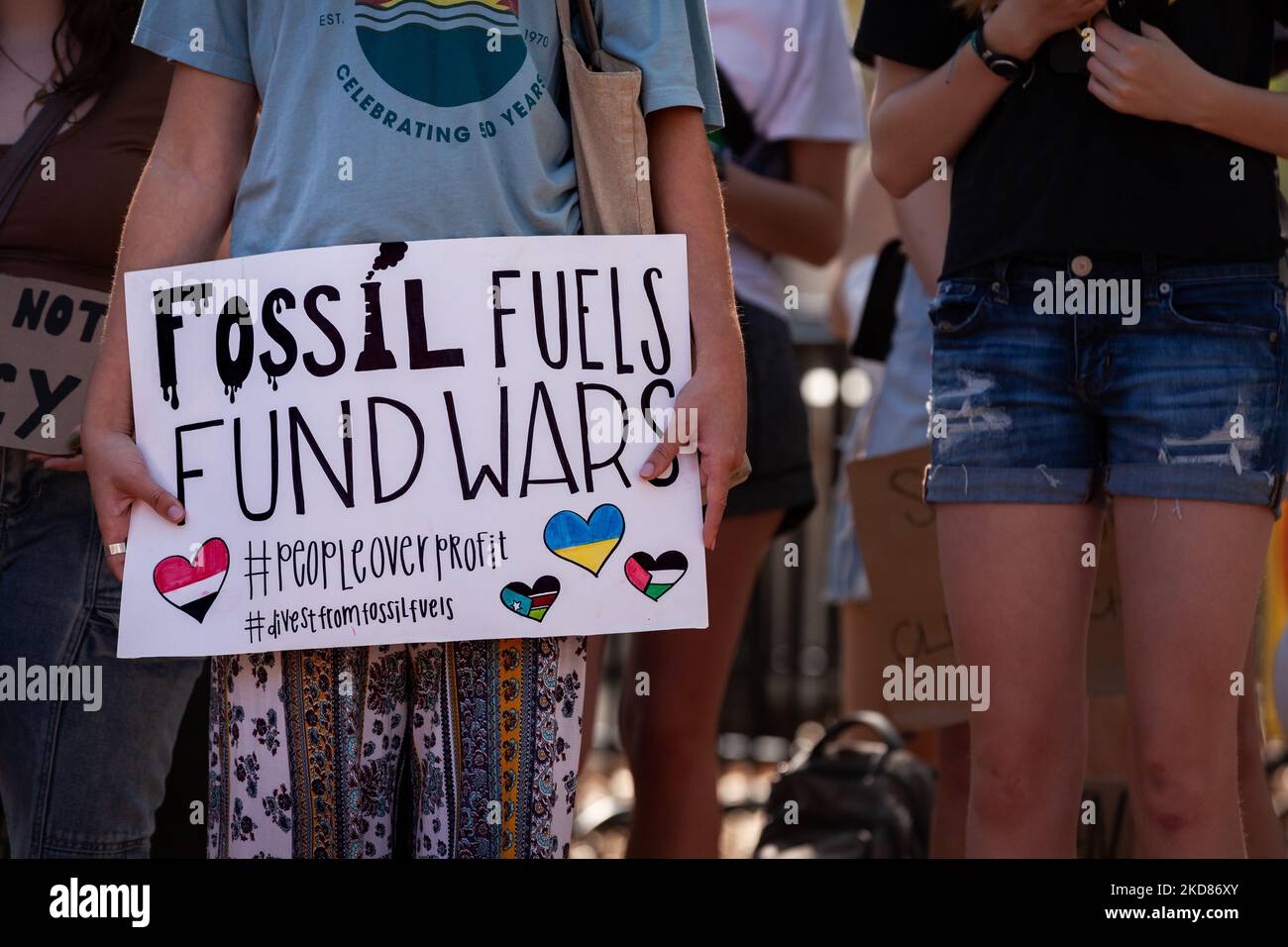 Ein Demonstrator zeigt ein Schild, das fossile Brennstoffe freitags mit Kriegen rund um den Globus für den zukünftigen Klimaangriff am Erdtag verbindet. Die Demonstranten forderten, dass die Regierung Biden die Investitionen in und den Bau der Infrastruktur für fossile Brennstoffe einstellt und stattdessen diese Ressourcen in erneuerbare Energien investiert. (Foto von Allison Bailey/NurPhoto) Stockfoto