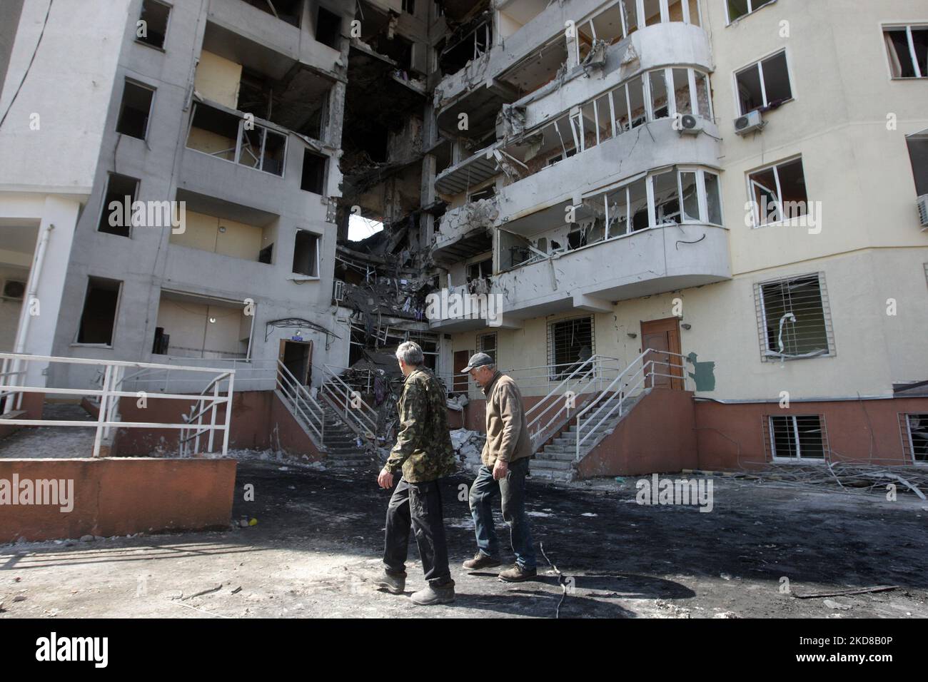 Die Menschen gehen ins Netz zu einem Wohngebäude, das am 24. April 2022 von einem Raketenangriff in Odesa, Ukraine, getroffen wurde. Am 23. April berichteten ukrainische Beamte, dass Russland sechs Raketen auf Odesa abgefeuert habe und dabei mindestens acht Menschen, darunter ein Baby, getötet habe. (Foto von STR/NurPhoto) Stockfoto