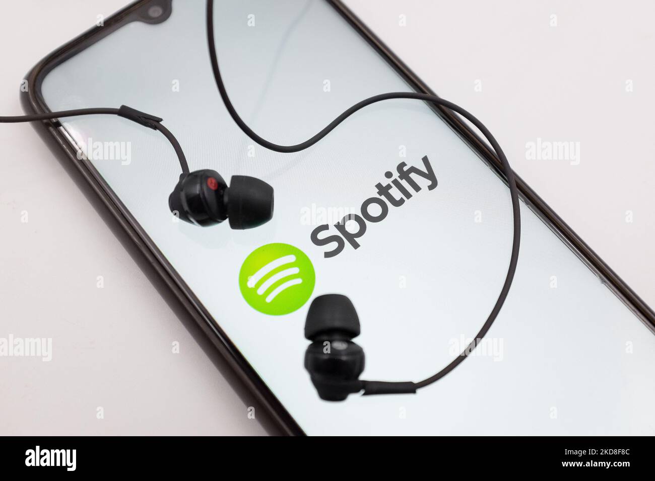 In dieser Abbildung wird das Spotify-Logo am 26. April 2022 auf einem Smartphone-Bildschirm mit Kopfhörern in Chania, Kreta, Griechenland, angezeigt. (Fotoillustration von Nikolas Kokovlis/NurPhoto) Stockfoto