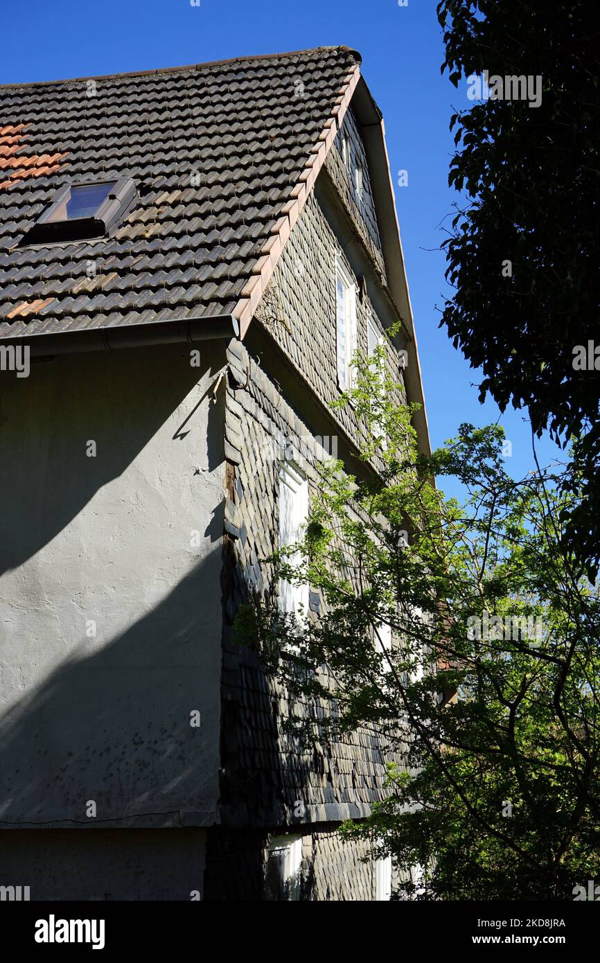 Eine vertikale Aufnahme eines Hauses mit den Bäumen vor dem blauen Himmel Stockfoto