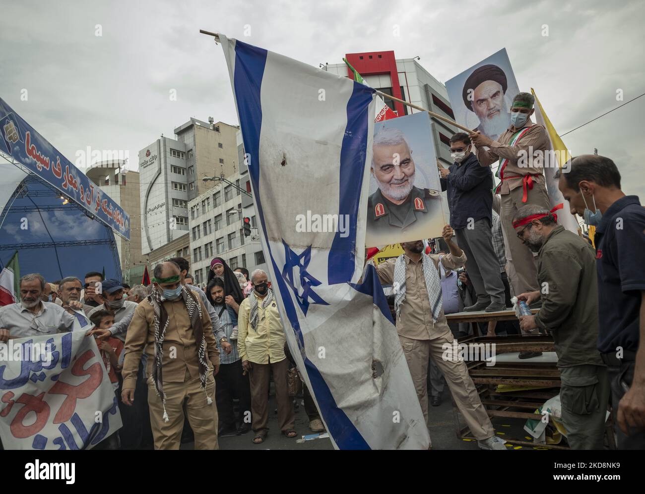 Iranische Demonstranten, die eine israelische Flagge vorbereiten, um in Brand zu gehen, während die anderen Demonstranten Porträts der Quds Force des ehemaligen Kommandanten des iranischen Korps der Islamischen Revolutionsgarde (IRGC), General Qasem Soleimani (C), Und der verstorbene iranische Führer Ayatollah Ruhollah Khomeini im Stadtzentrum von Teheran bei einer Kundgebung zum Gedenken an den Internationalen Quds-Tag, der auch als Jerusalemtag bekannt ist, am 29. April 2022. (Foto von Morteza Nikoubazl/NurPhoto) Stockfoto