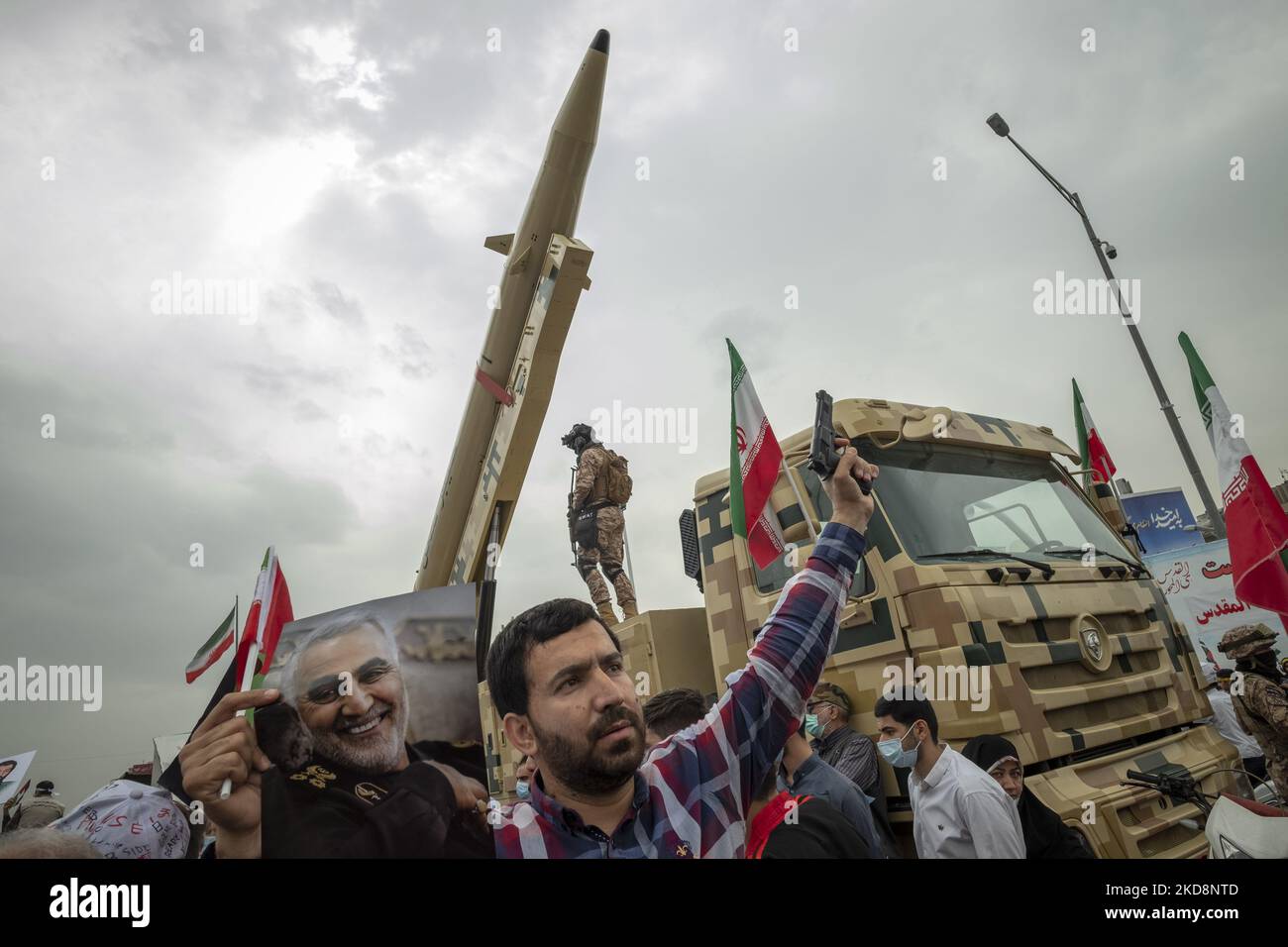 Ein iranischer Demonstrator hält eine Pistolenpistole aus Kunststoff als Porträt des ehemaligen Kommandanten des iranischen Quds-Trupps der Islamischen Revolutionsgarde (IRGC), General Qasem Soleimani, während er während einer Kundgebung zum Internationalen Quds-Tag auf einer iranischen Kheibar-Shekan-Ballistikrakete in der Innenstadt von Teheran stand, Auch bekannt als der Jerusalem-Tag, am 29. April 2022. (Foto von Morteza Nikoubazl/NurPhoto) Stockfoto