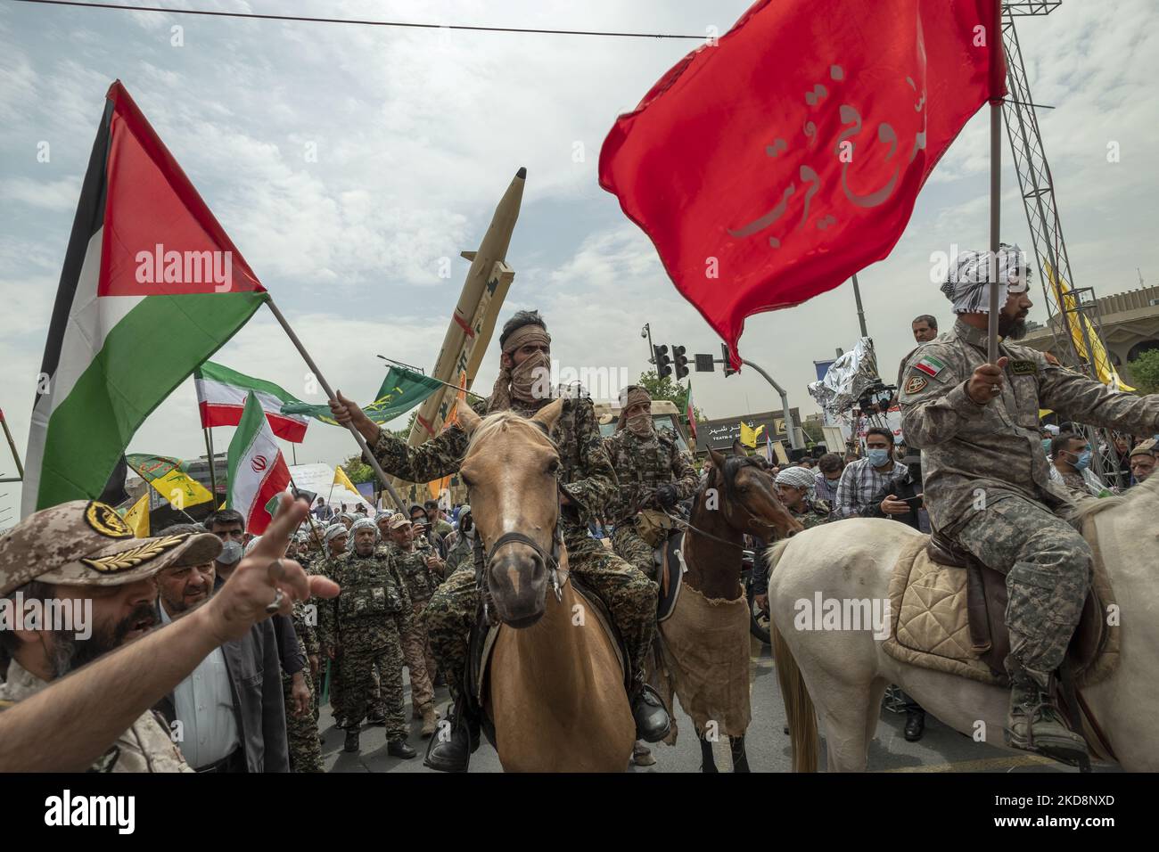 Ein Militärpersonal der Islamischen Revolutionsgarde (IRGC), das eine palästinensische Flagge trägt, während er auf einem Pferd unter einer iranischen Kheibar-Shekan-Ballistikrakete in der Innenstadt von Teheran während einer Kundgebung zum Gedenken an den Internationalen Quds-Tag, der auch als Jerusalemtag bekannt ist, am 29. April 2022 ritt. (Foto von Morteza Nikoubazl/NurPhoto) Stockfoto