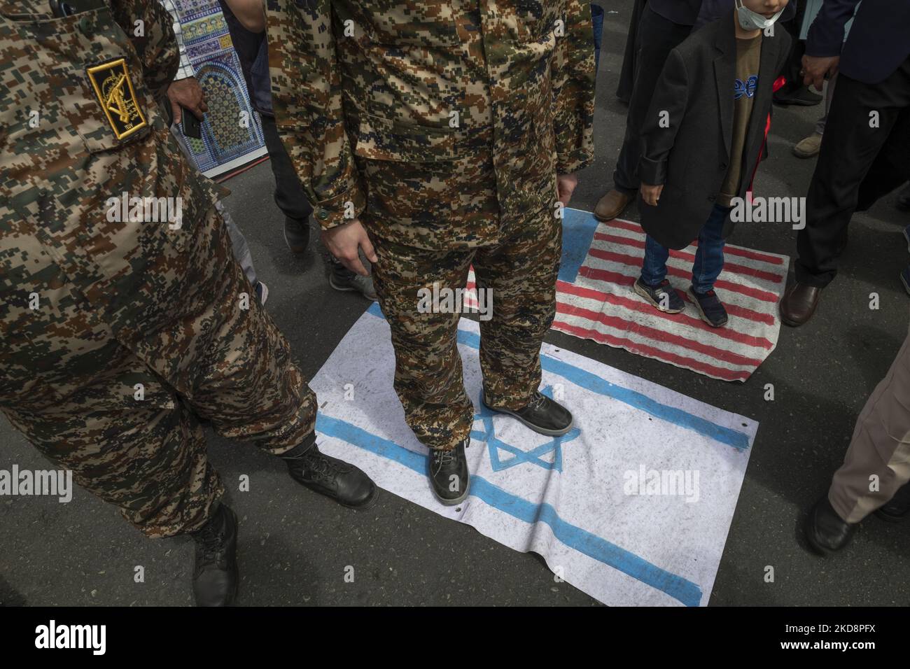 Ein Militärpersonal der Islamischen Revolutionsgarde (IRGC) steht auf einer israelischen Flagge während einer Kundgebung zum Internationalen Quds-Tag, auch bekannt als Jerusalem-Tag, in der Innenstadt von Teheran am 29. April 2022. (Foto von Morteza Nikoubazl/NurPhoto) Stockfoto