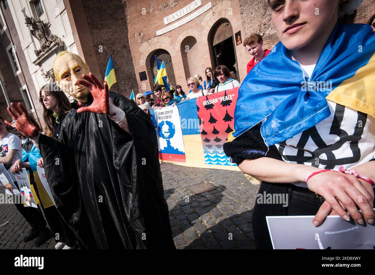 Ein Mann mit einer Putin-Maske und blutigen Händen versucht, ein Mädchen während der Flashmob-Demonstration der ukrainischen Gemeinschaft in Rom am 01. Mai 2022 in Rom, Italien, zu erwürgen. (Foto von Andrea Ronchini/NurPhoto) Stockfoto