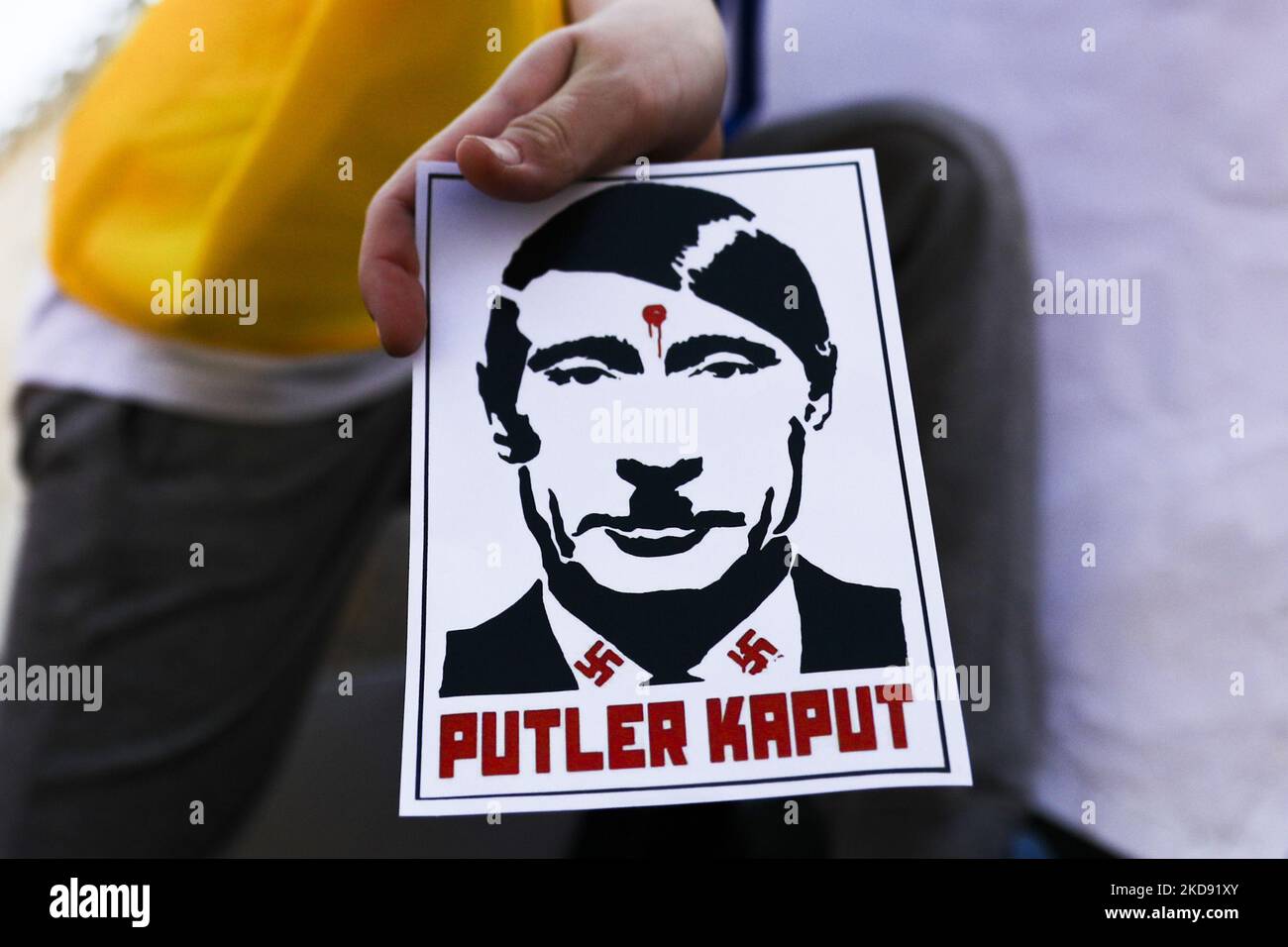 Ein Plakat mit Wladimir Putin, das als Adolf Hitler gezeigt wird, und die Phrase „Putler Kaput“, wird während einer Solidaritätsdemonstration mit der Ukraine auf dem Hauptplatz gesehen, die die NATO auffordert, den Himmel für russische Flugzeuge über dem Gebiet der Ukraine nach der russischen Invasion zu schließen. Krakau, Polen, am 2.. Mai 2022. (Foto von Beata Zawrzel/NurPhoto) Stockfoto