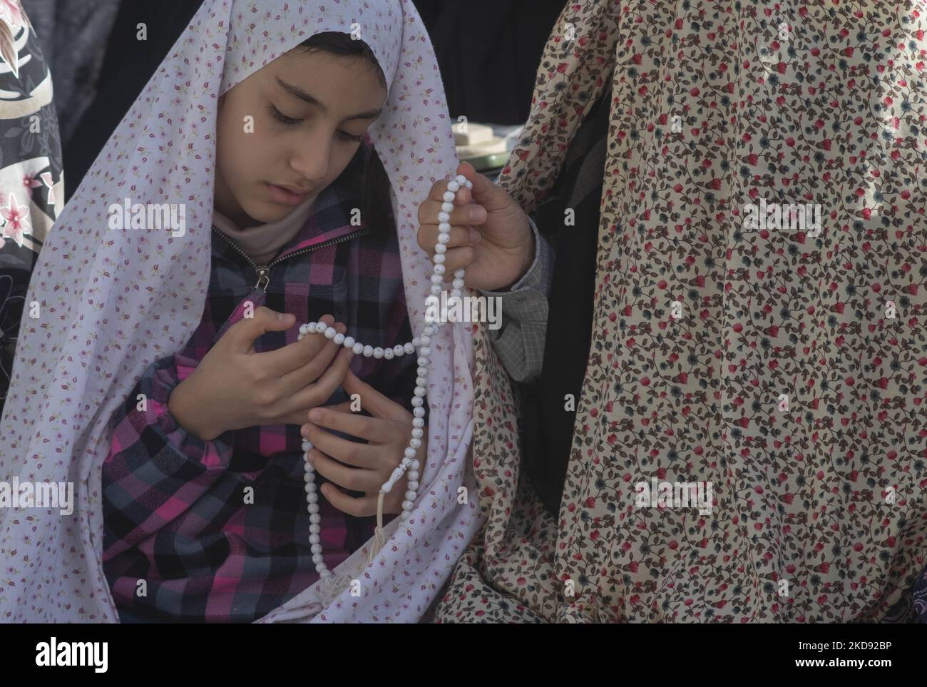 Eine schiitische muslimische Frau und ihre junge Tochter beten nach der Eid-al-Fitr-Gebetszeremonie in Qom, 145 Kilometer südlich von Teheran, zwei Jahre nach dem Ausbruch des neuen Coronavirus (COVID-19) am 3. Mai 90 2022 in der heiligen Moschee von Jamkaran. (Foto von Morteza Nikoubazl/NurPhoto) Stockfoto