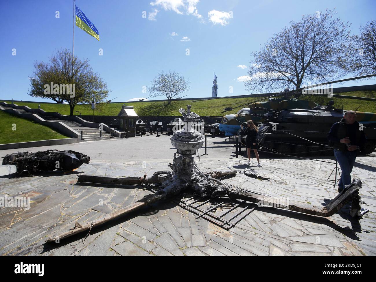 Während der Feierlichkeiten zum Siegestag, inmitten der russischen Invasion in der Ukraine, in Kiew, Ukraine, am 9. Mai 2022, blicken die Menschen auf Trümmer des zerstörten russischen Hubschraubers, die im Freilichtmuseum des Zweiten Weltkriegs ausgestellt sind. Die Ausstellung „Ukraine: Kreuzigung“, die der russischen Invasion in der Ukraine gewidmet ist, wurde im Nationalmuseum für Geschichte der Ukraine im Zweiten Weltkrieg eröffnet (Foto von STR/NurPhoto) Stockfoto